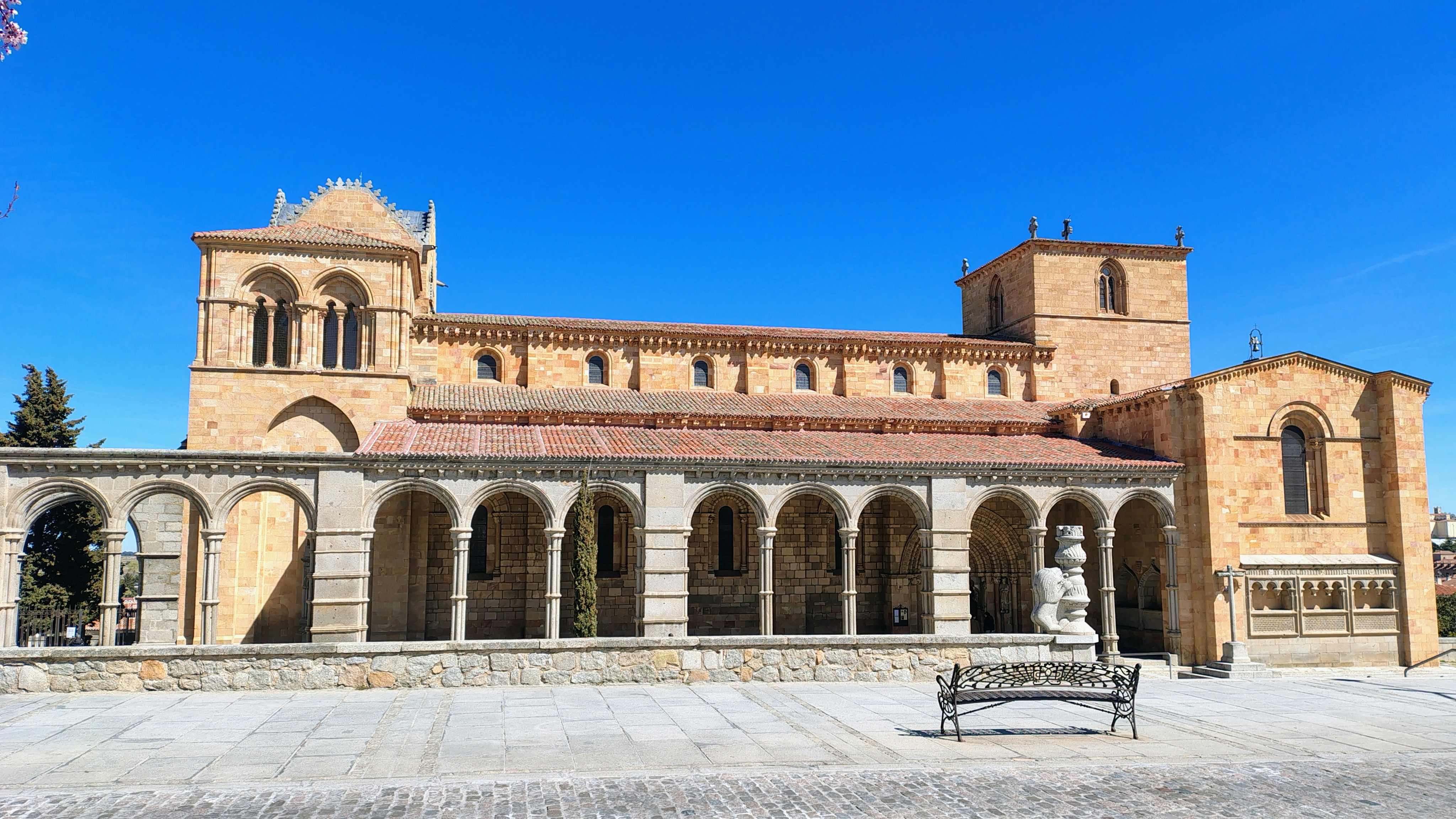 Historic stone church with arched facade and clear blue sky.