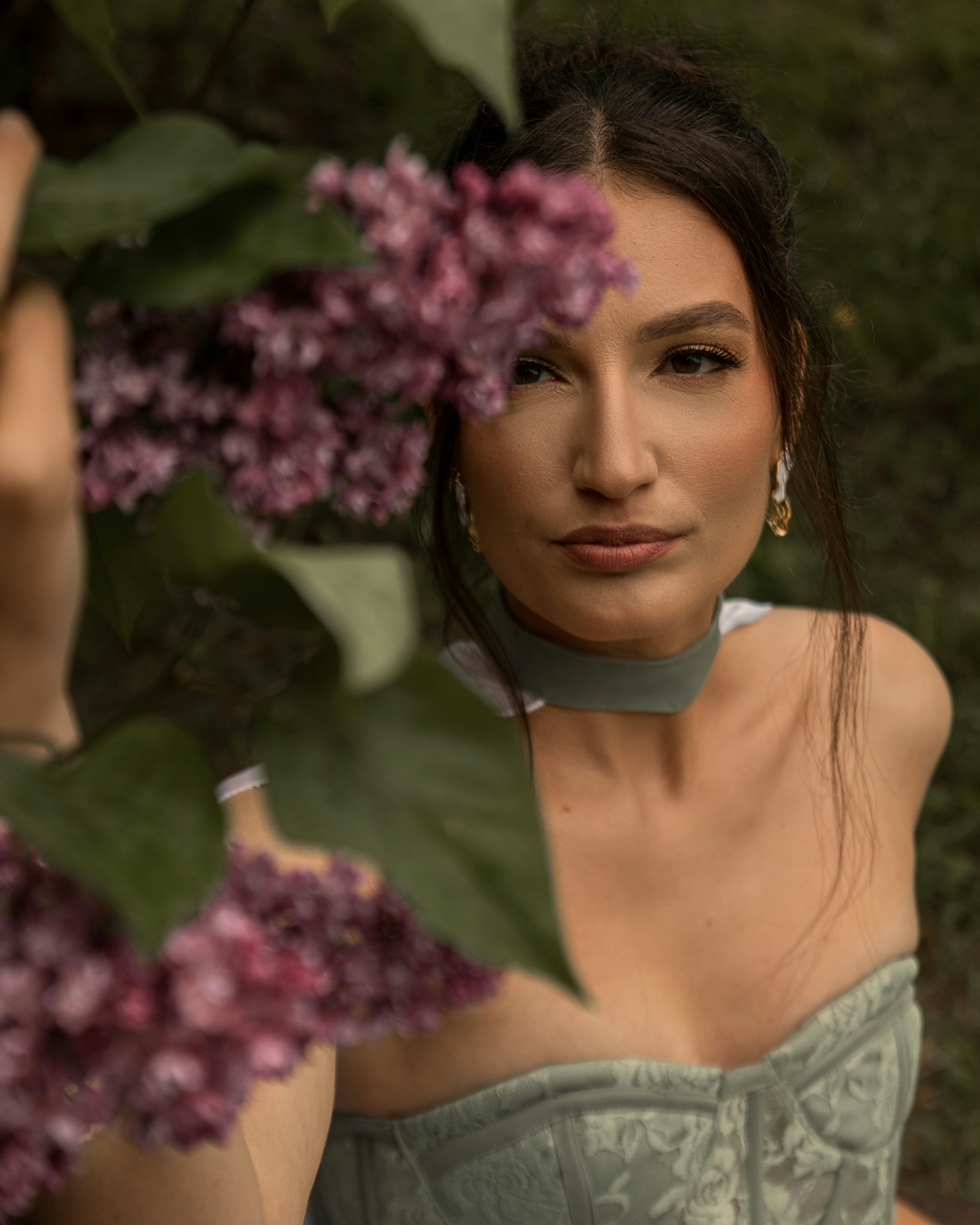 Mulher linda olhando através das flores de lilás roxo.