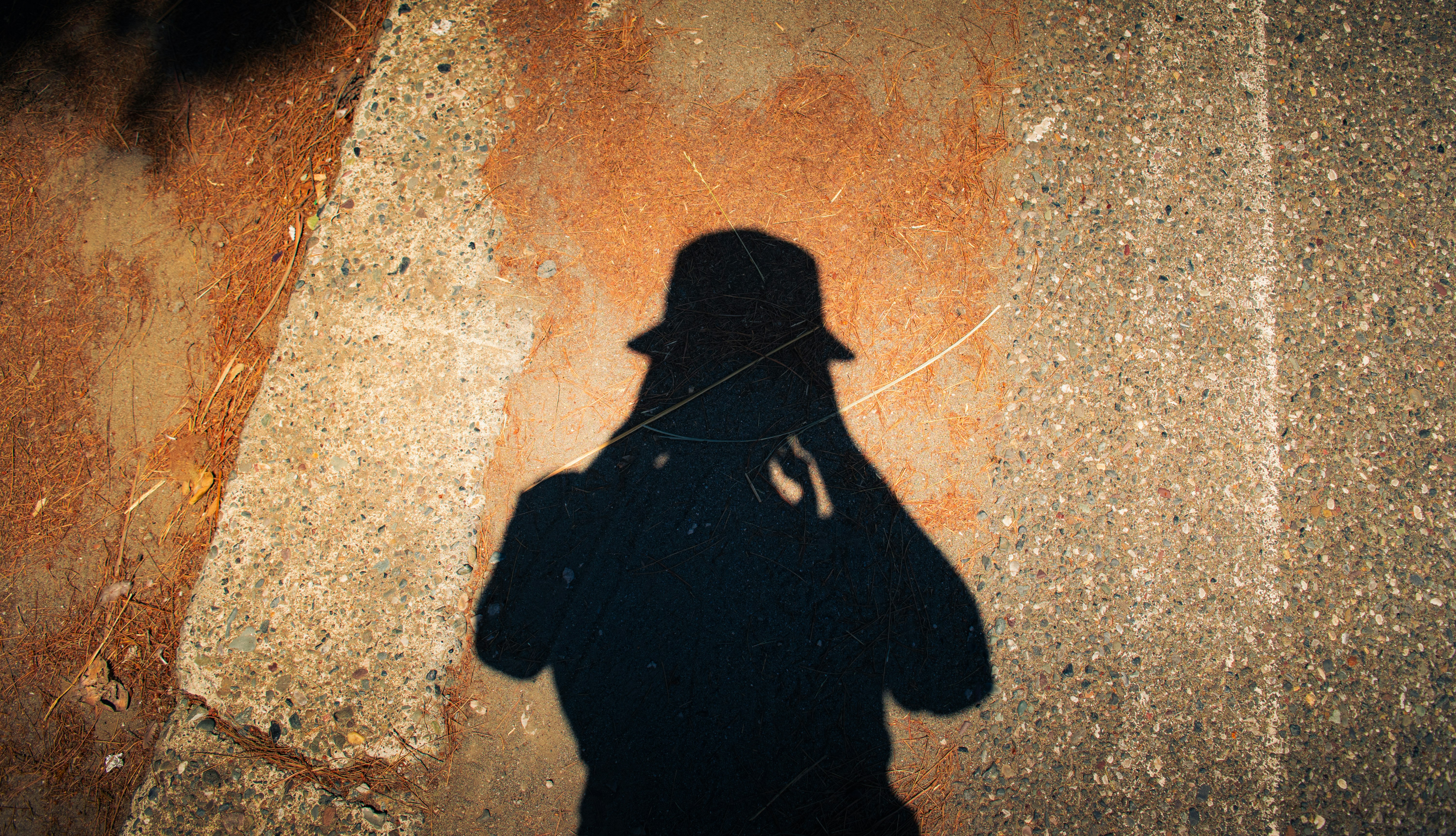 Shadow of a person in a hat on textured ground. - 相关推荐