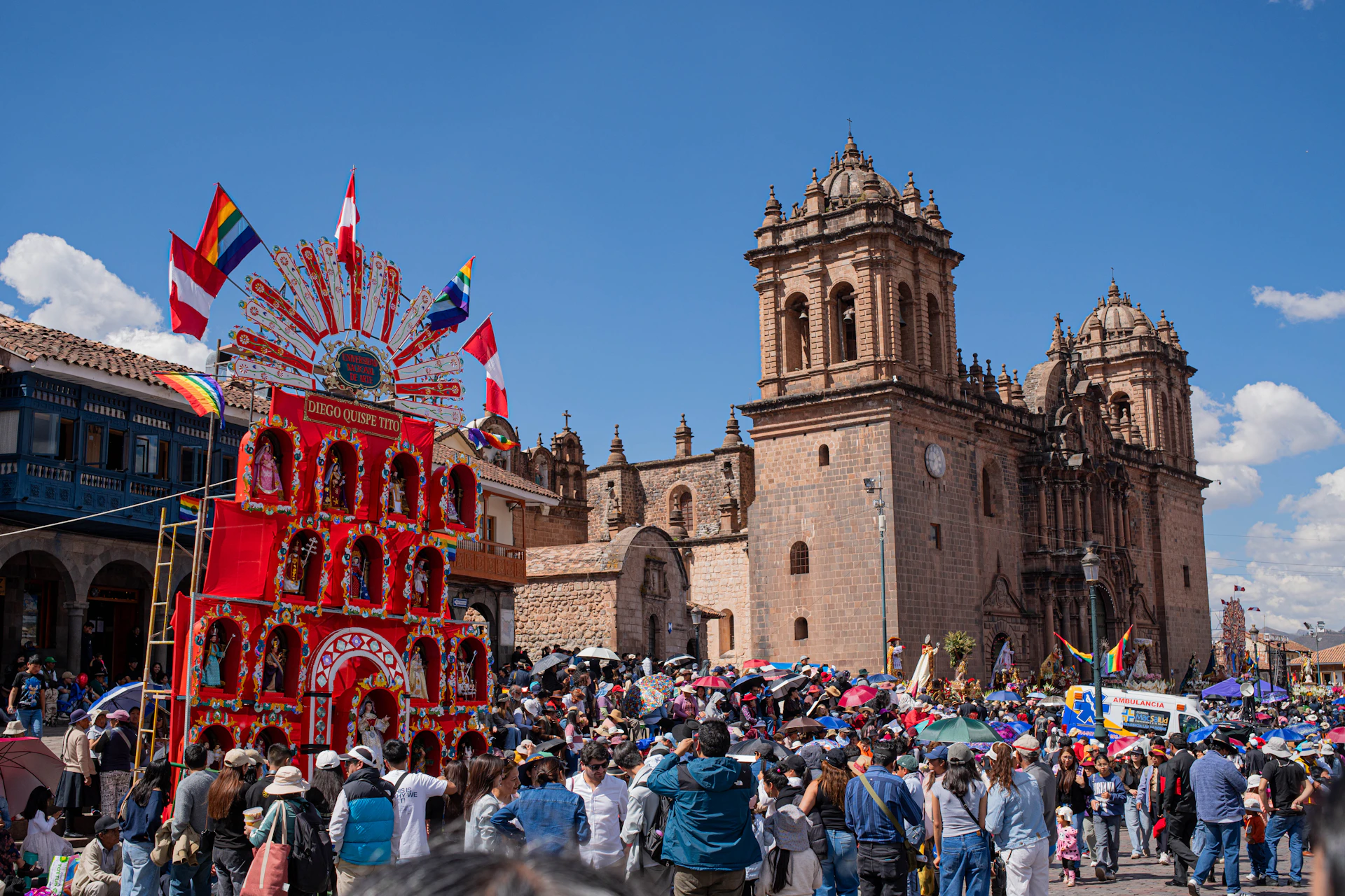 Festive crowd gathers near a decorated float and historic church.