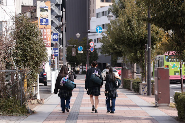 Tres estudiantes caminando vistos de espaldas