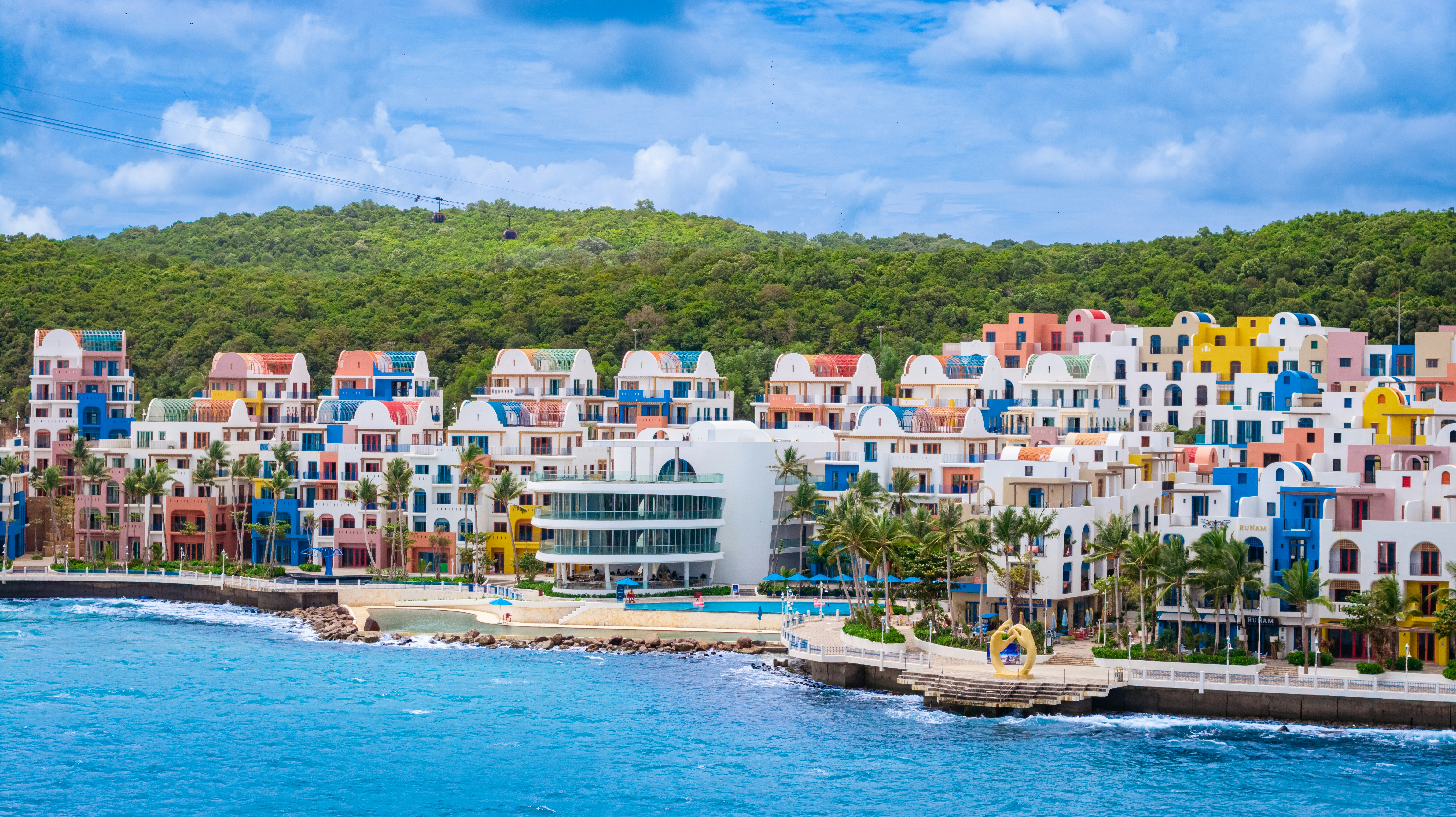 Vibrant buildings by a beach and blue ocean.