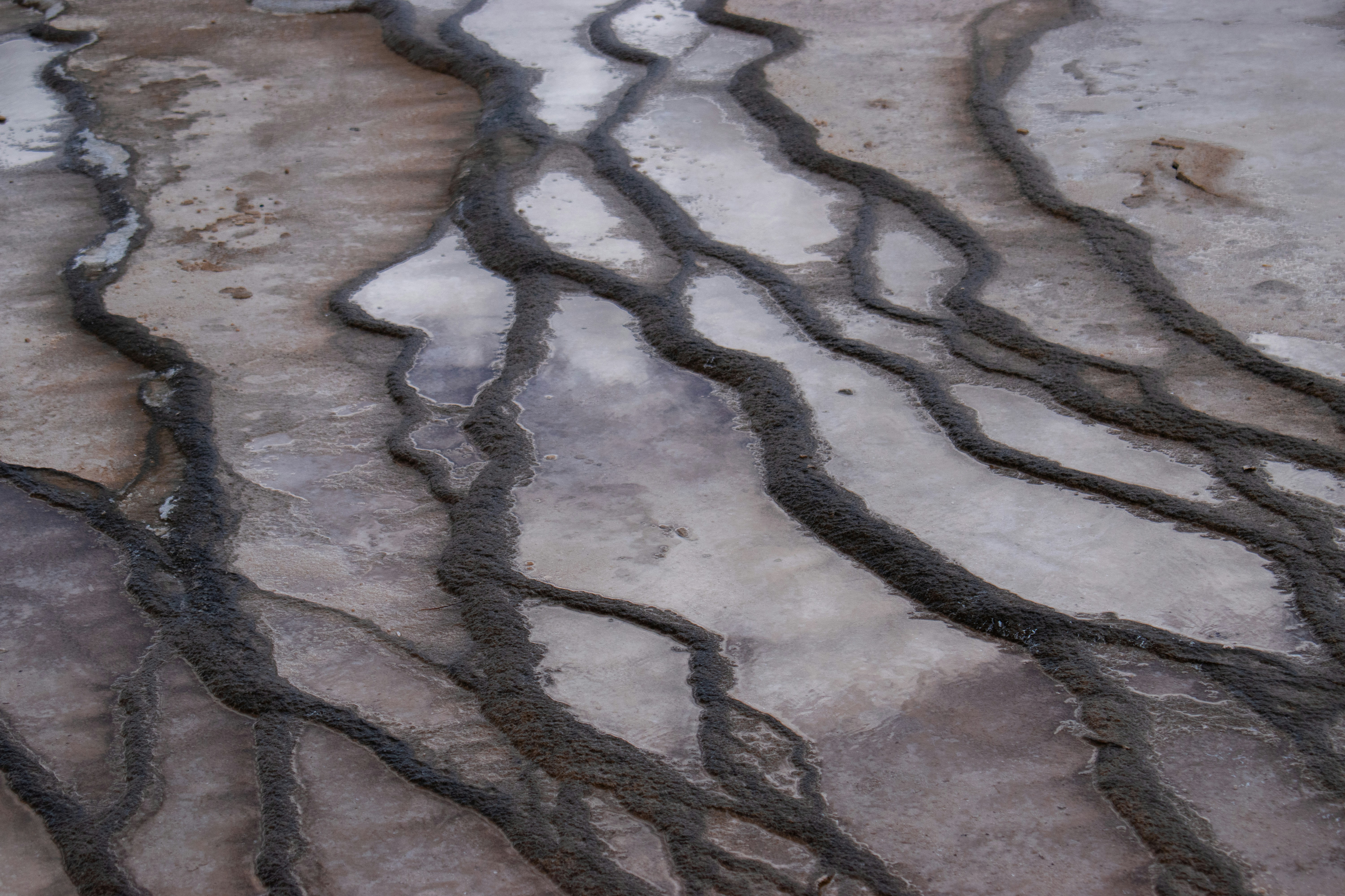Water flows through natural mineral terraces and intricate patterns.