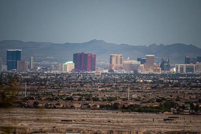 Las Vegas skyline framed by mountains with dry open desert in the foreground, showing the land constraints around the valley
