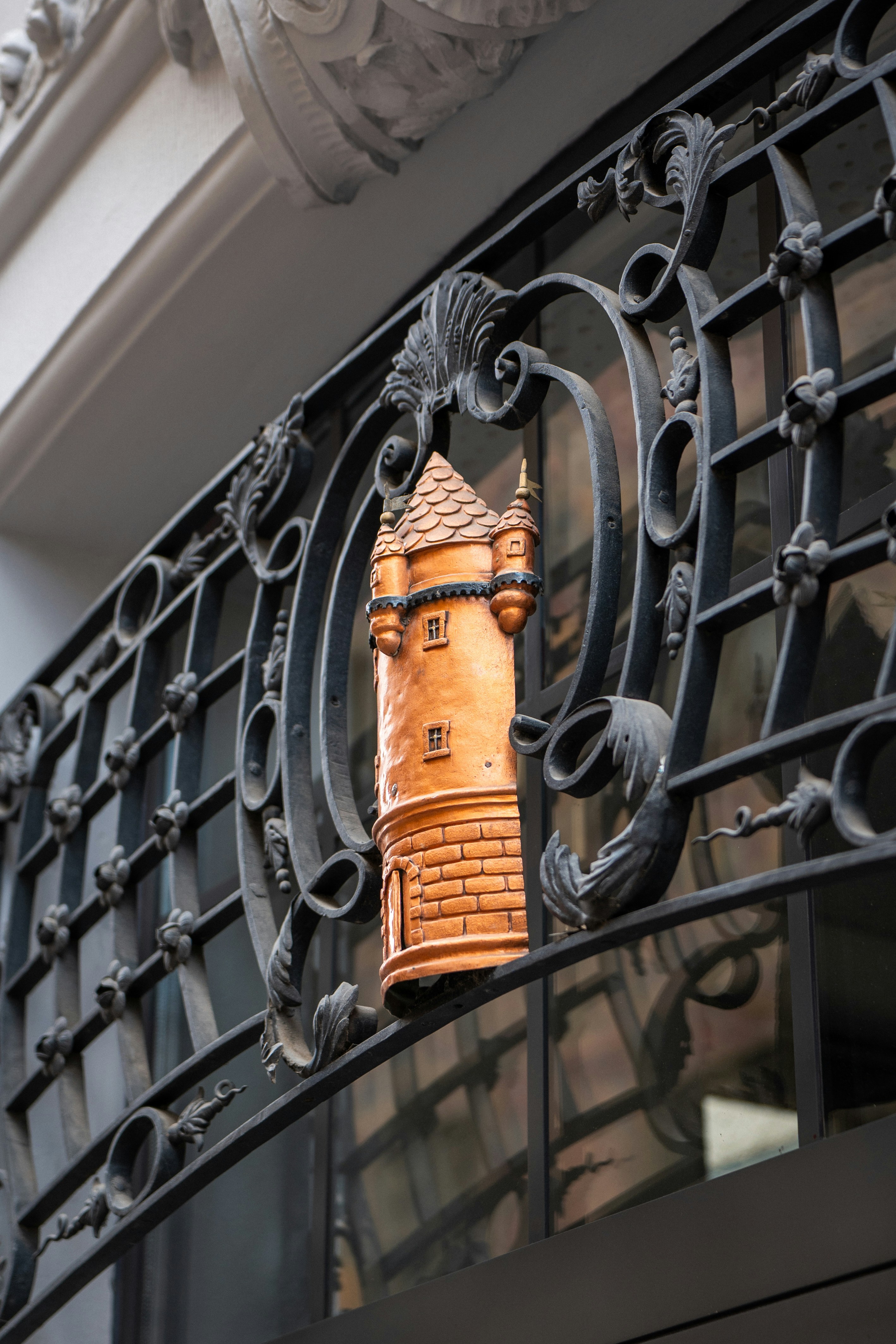 Decorative terracotta tower embedded in ornate wrought ironwork.