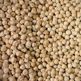 A full frame of dried, light brown chickpeas.