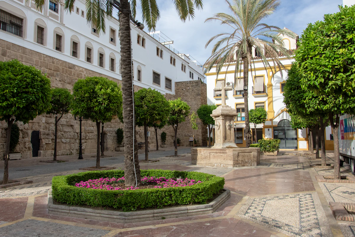 Plaça amb palmeres, font i edificis blancs