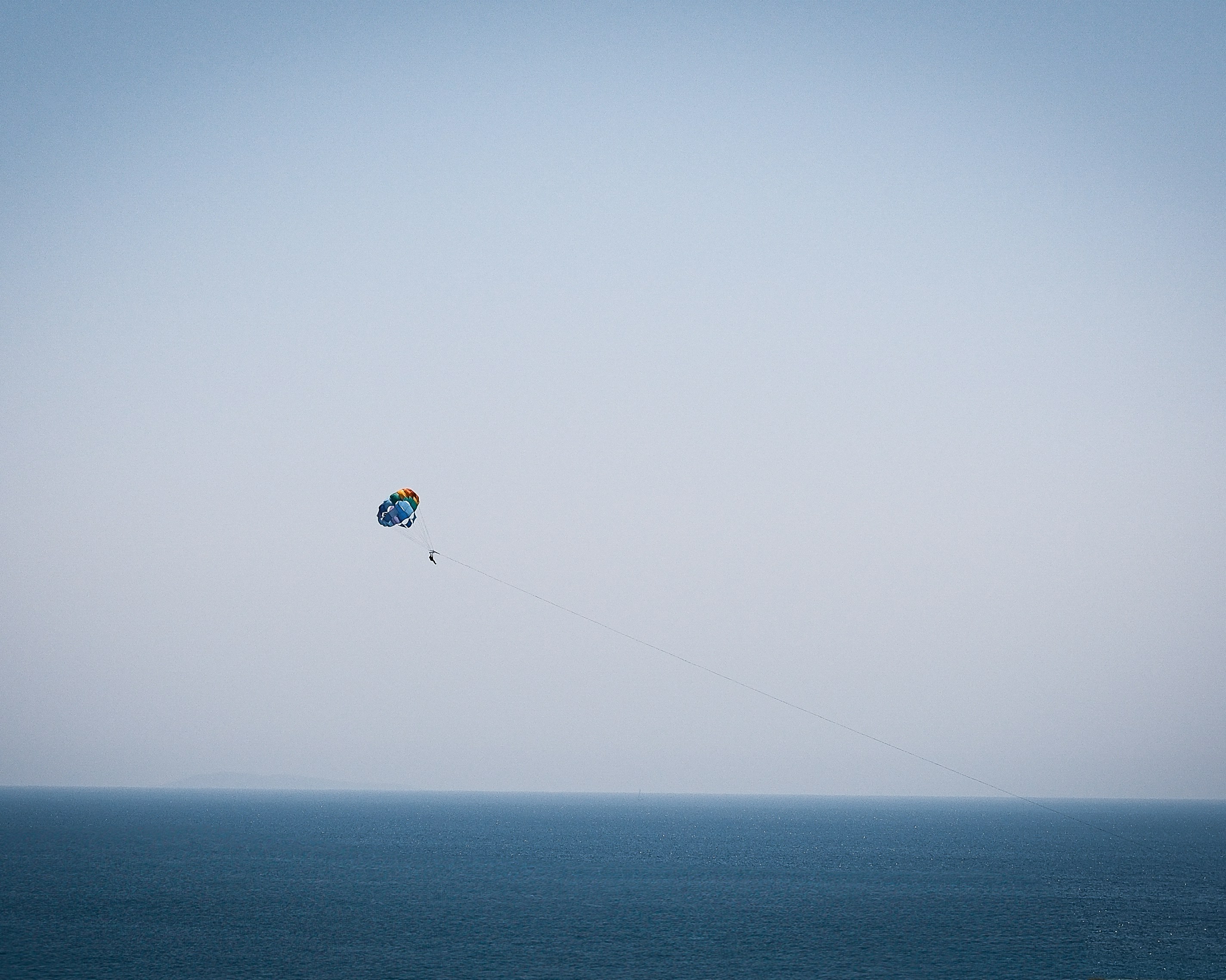 Parasailing over a calm blue ocean.