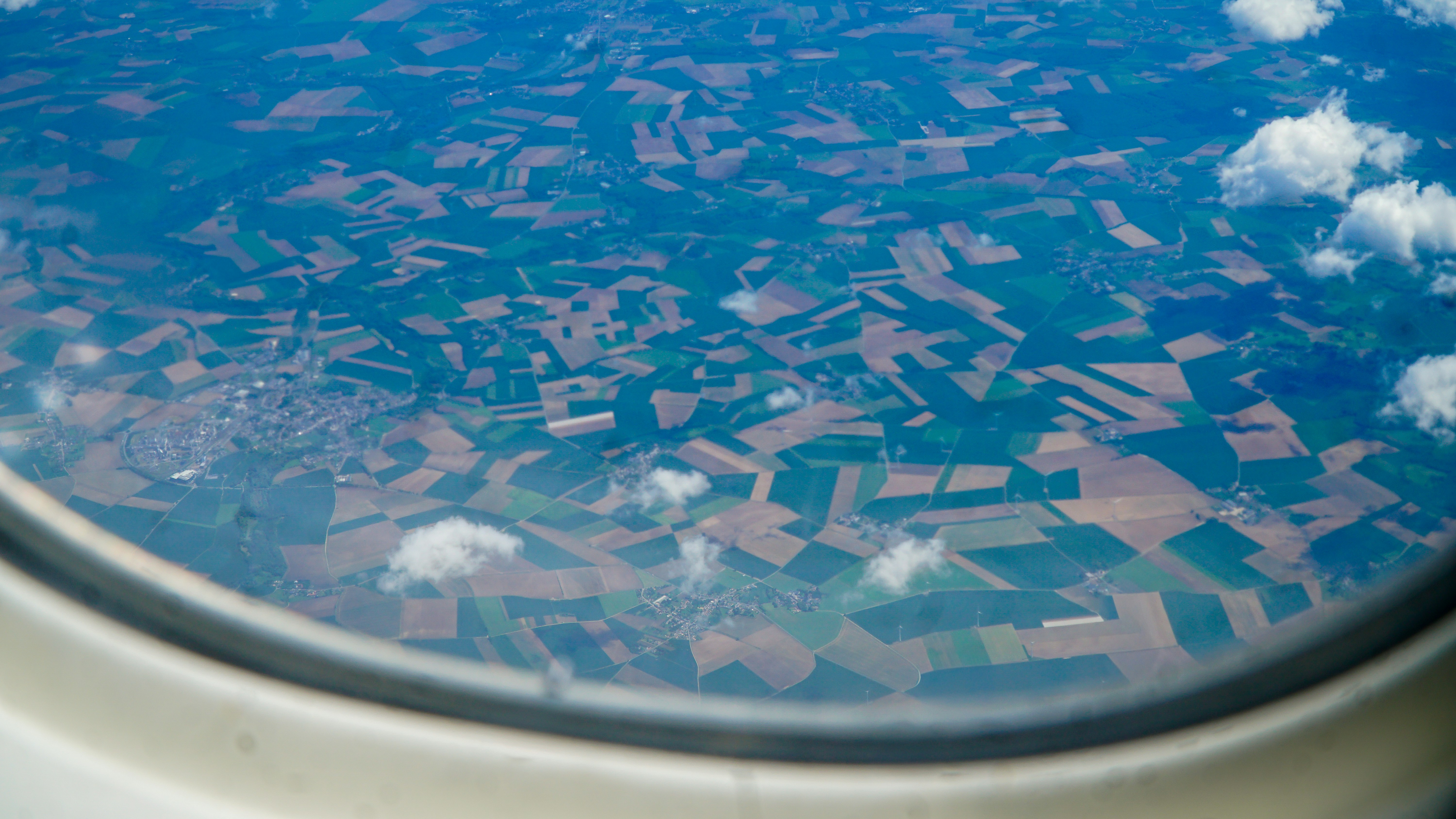 Aerial view of patchwork fields through an airplane window.