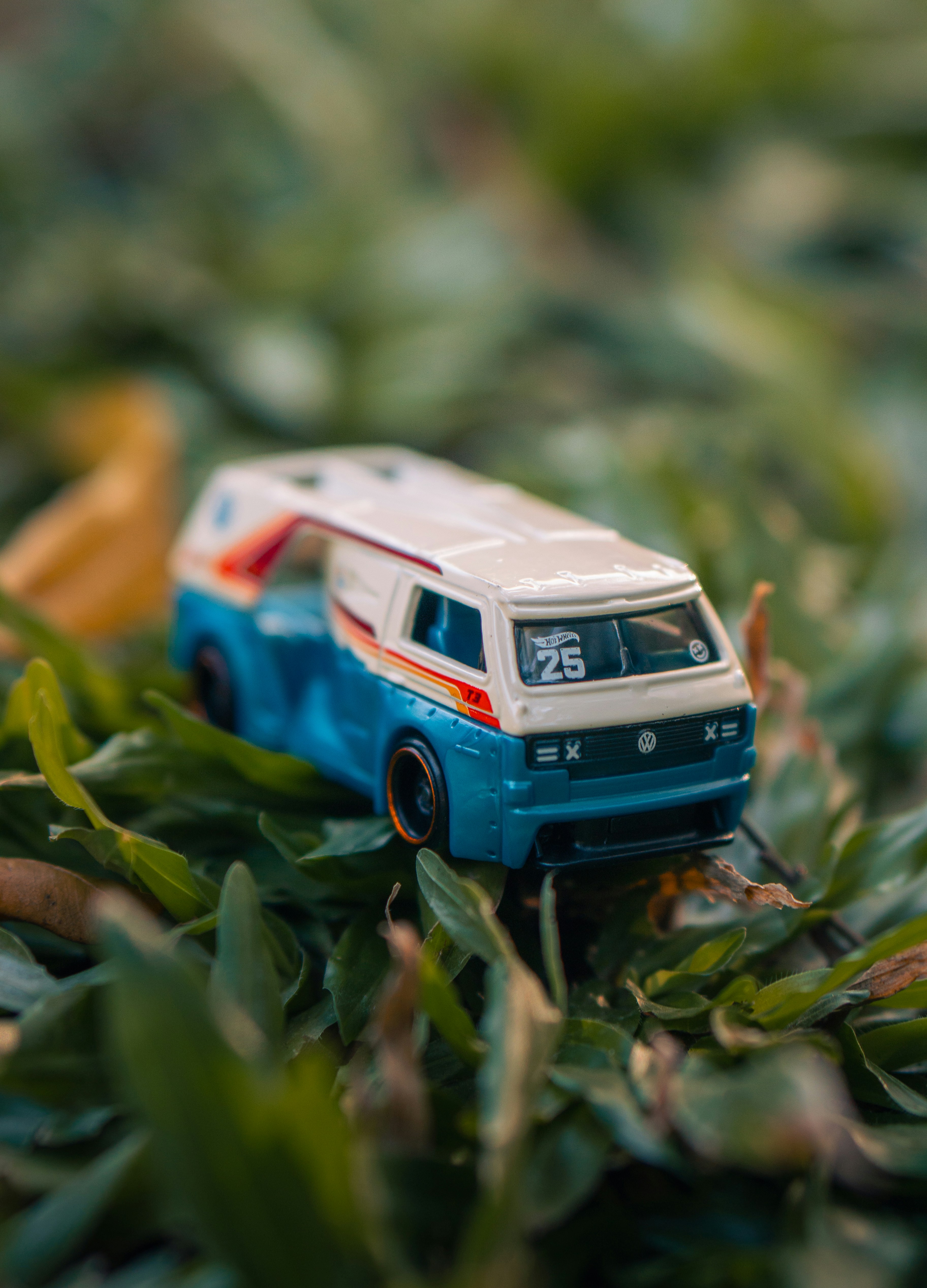 A blue and white toy volkswagen van on green grass.