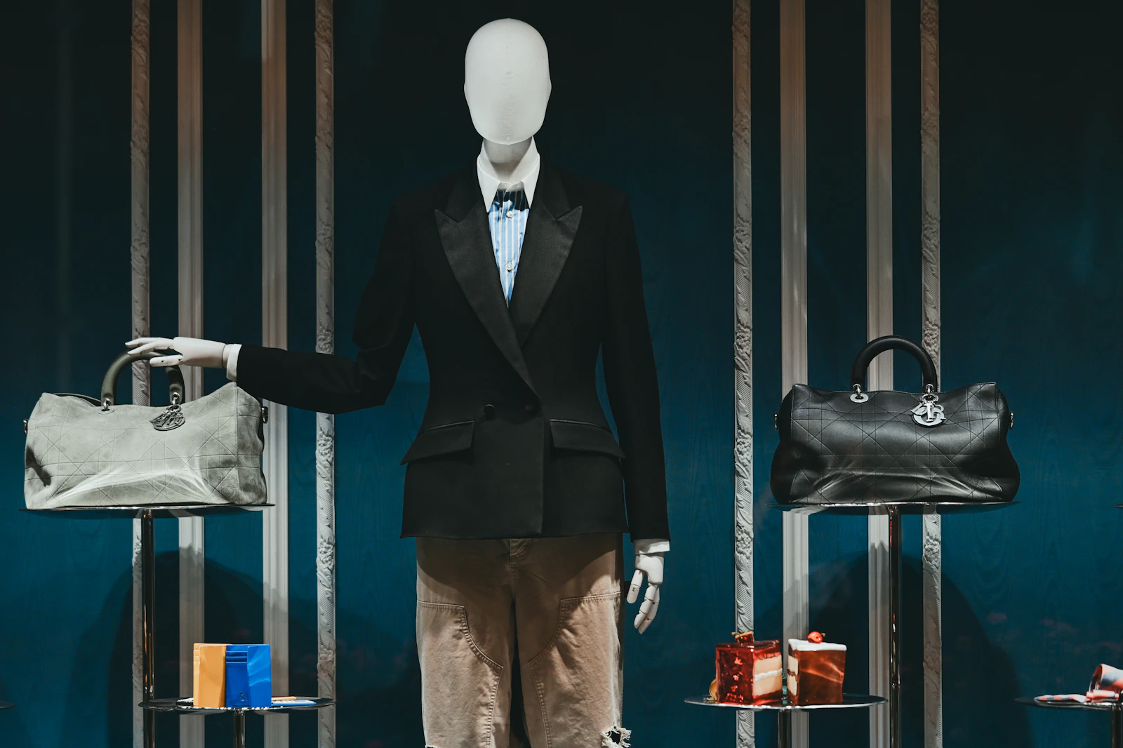 A boutique display with a tailored suit, handbags and gift boxes