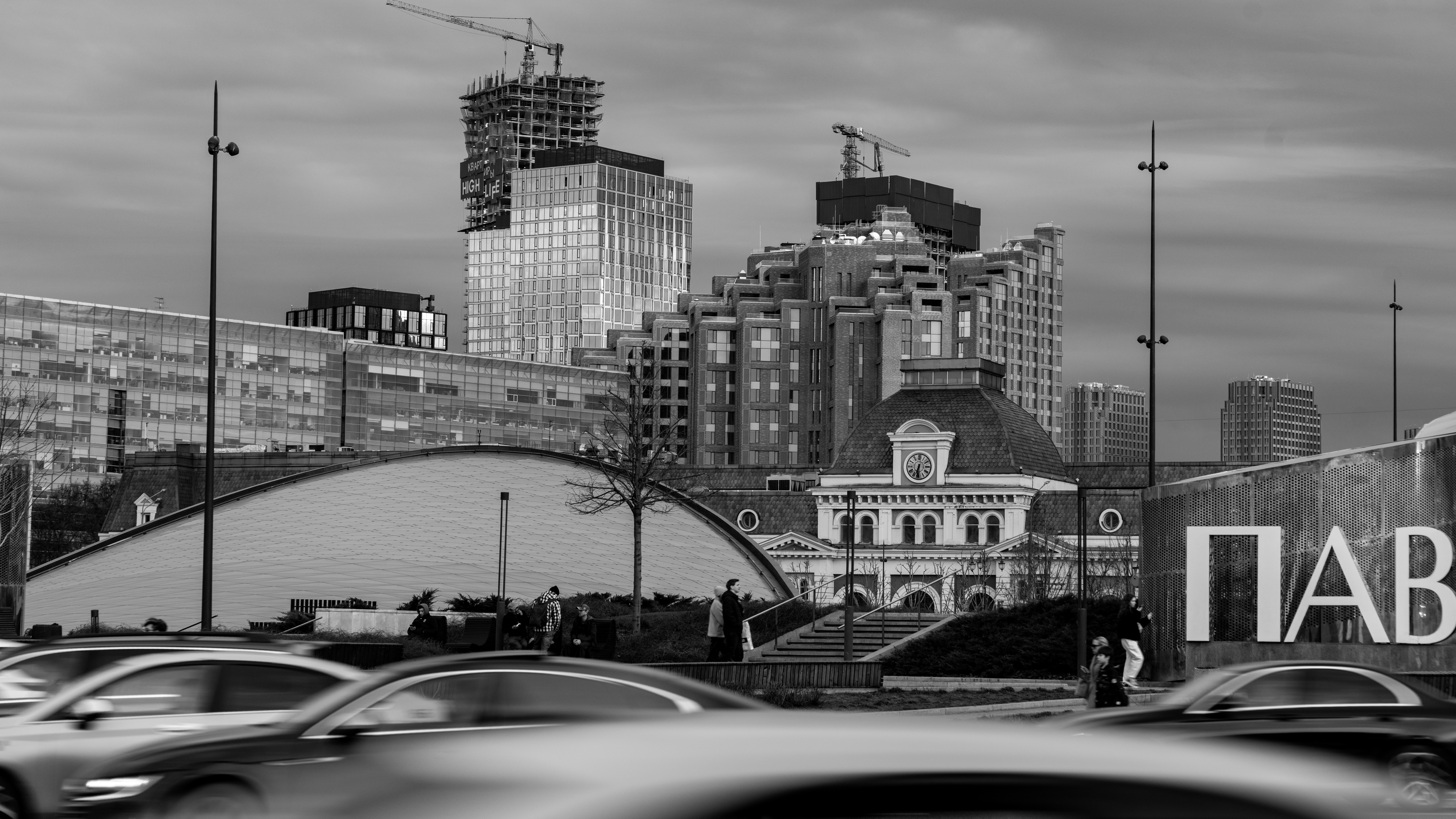 Grayscale city view featuring buildings, traffic, and construction.