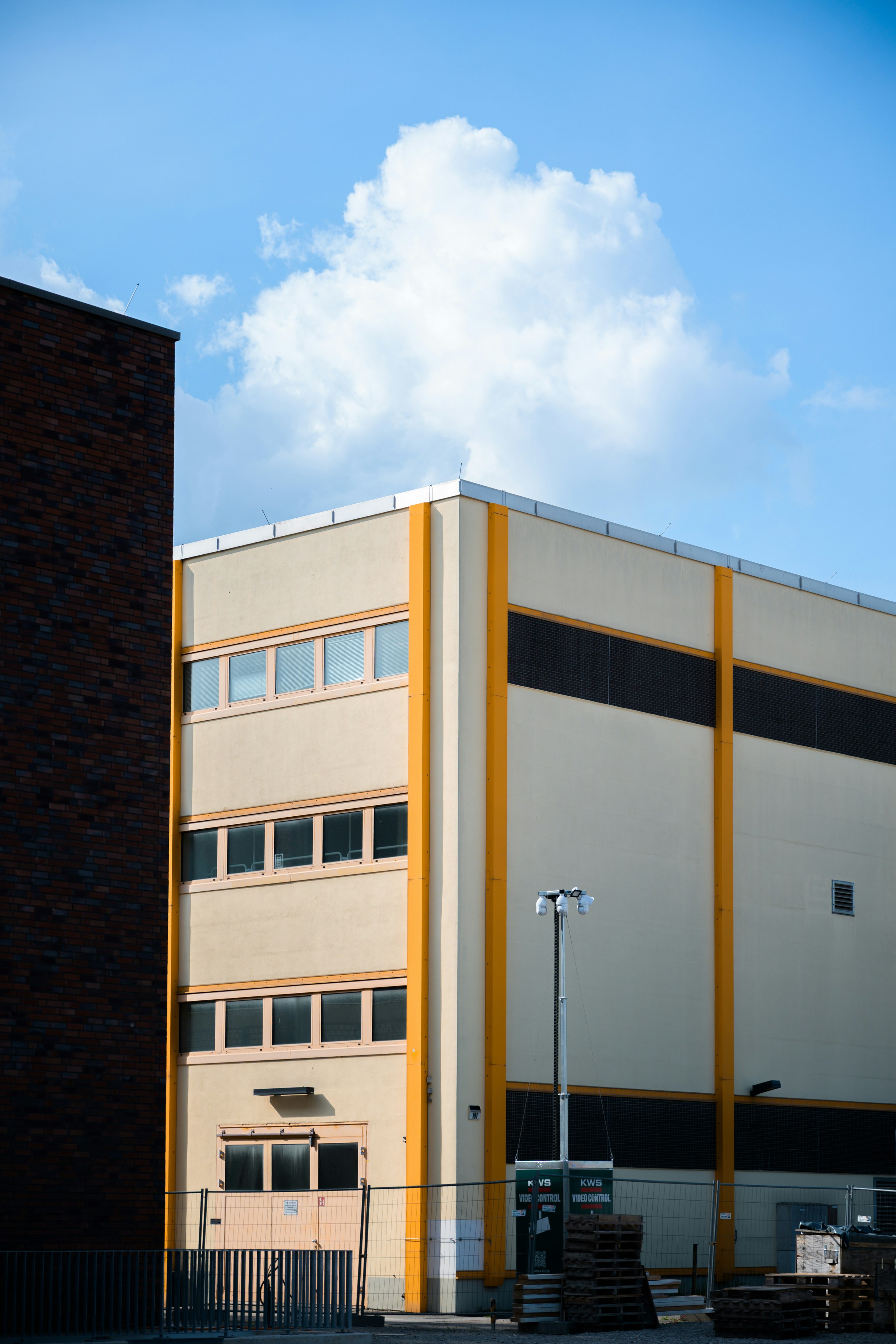 Building with yellow and black stripes under a blue sky.