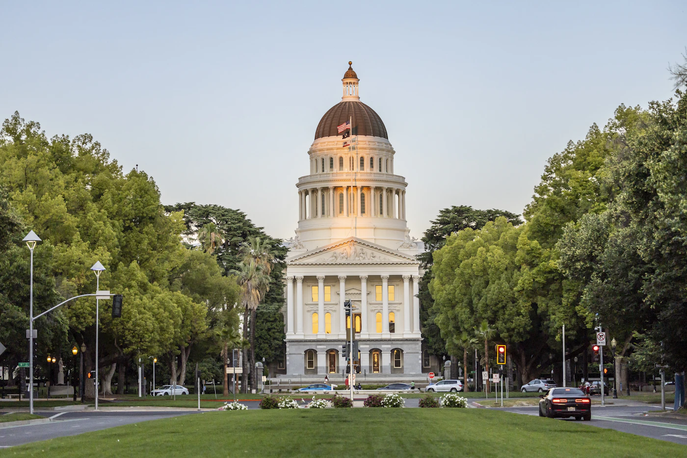 California state capitol building framed by trees and green lawn