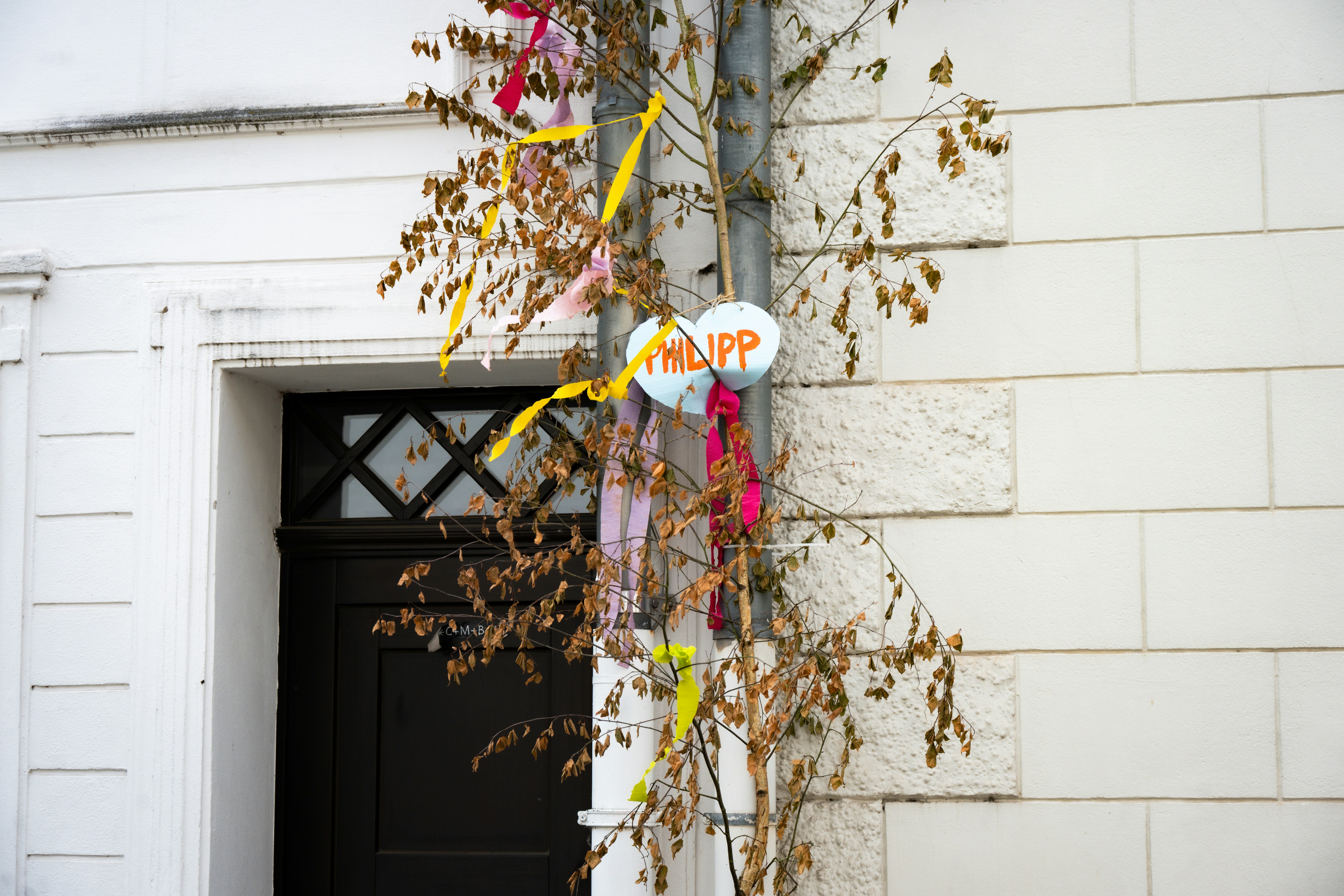 Weißes Gebäude, geschmückt mit bunten Bändern und "Philipp"-Luftballons.