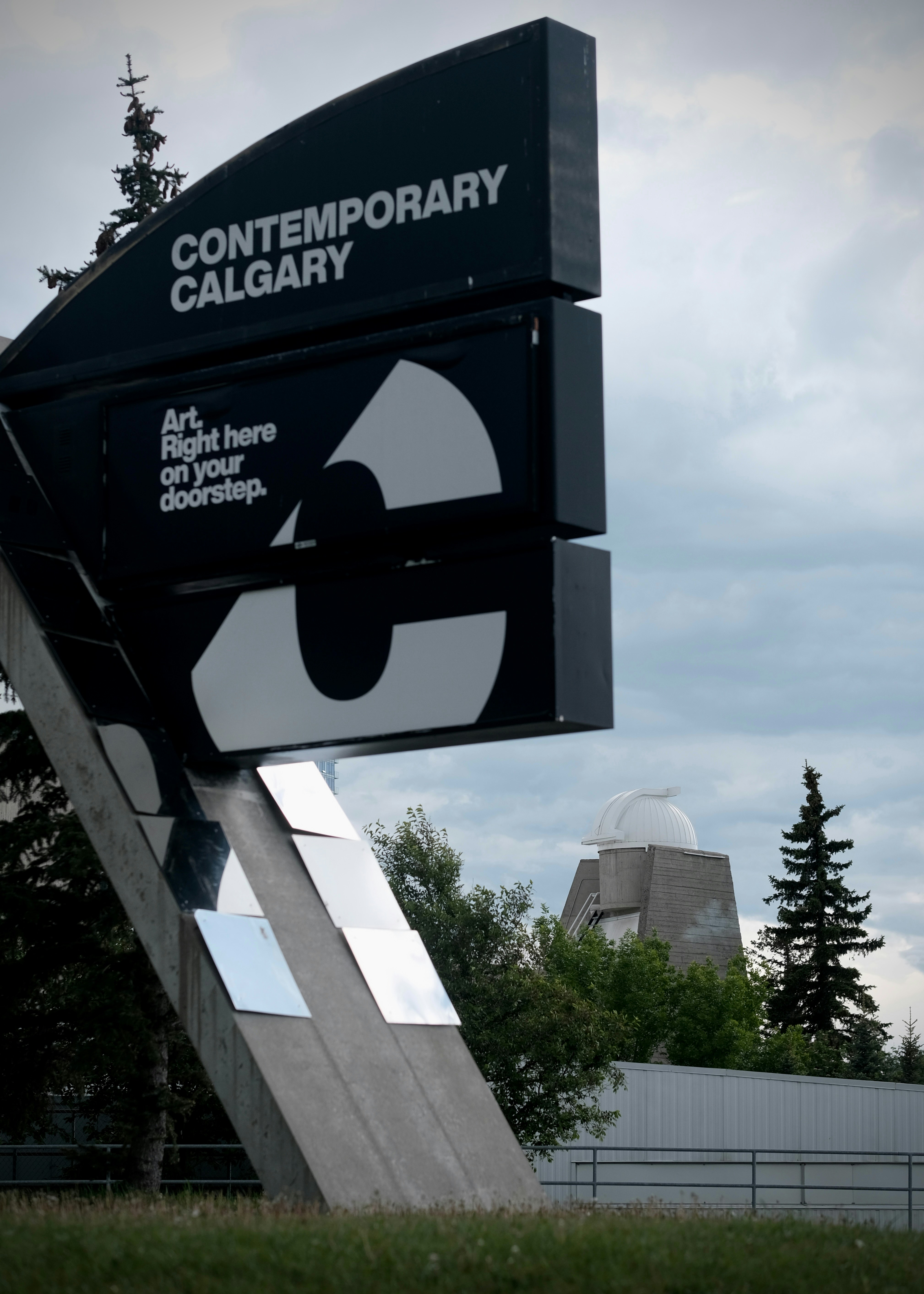 Large contemporary calgary sign with observatory building in background.