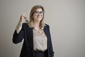 Professional woman smiling and presenting a set of keys.