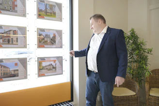 Man looking at real estate listings in a window display.