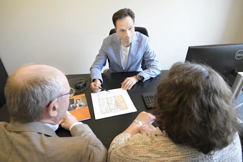 Consultant explains plans to a couple during a business meeting.