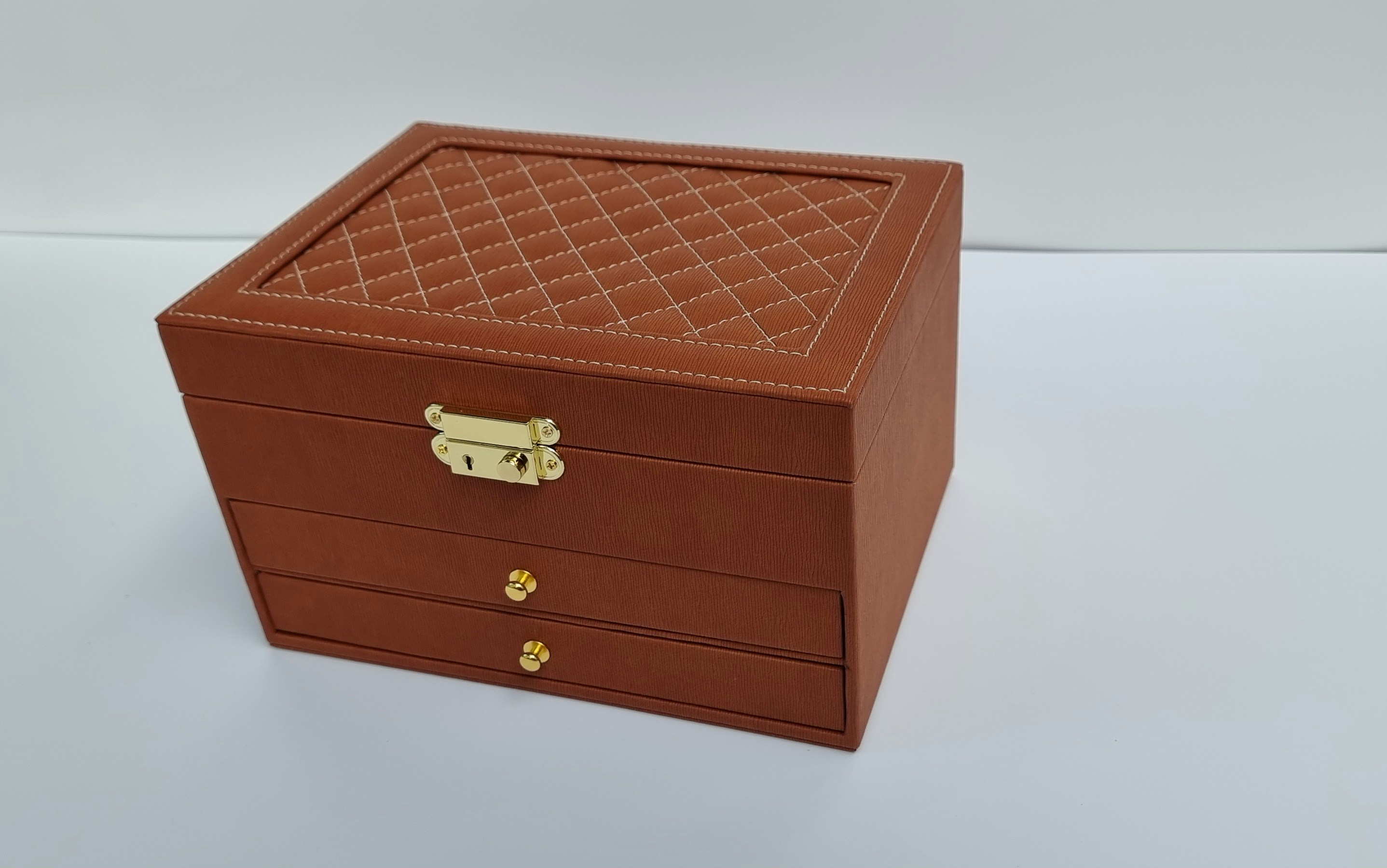 Elegante scatola marrone con top trapuntato e ferramenta dorata.