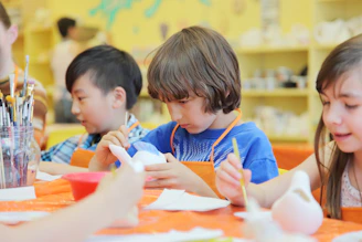 Children painting ceramic figures in an art class.