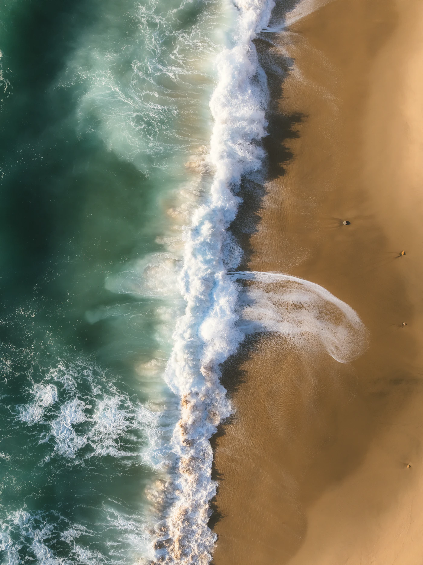 Turquoise wave peeling along the point at Jeffreys Bay, breaking cleanly toward the beach.