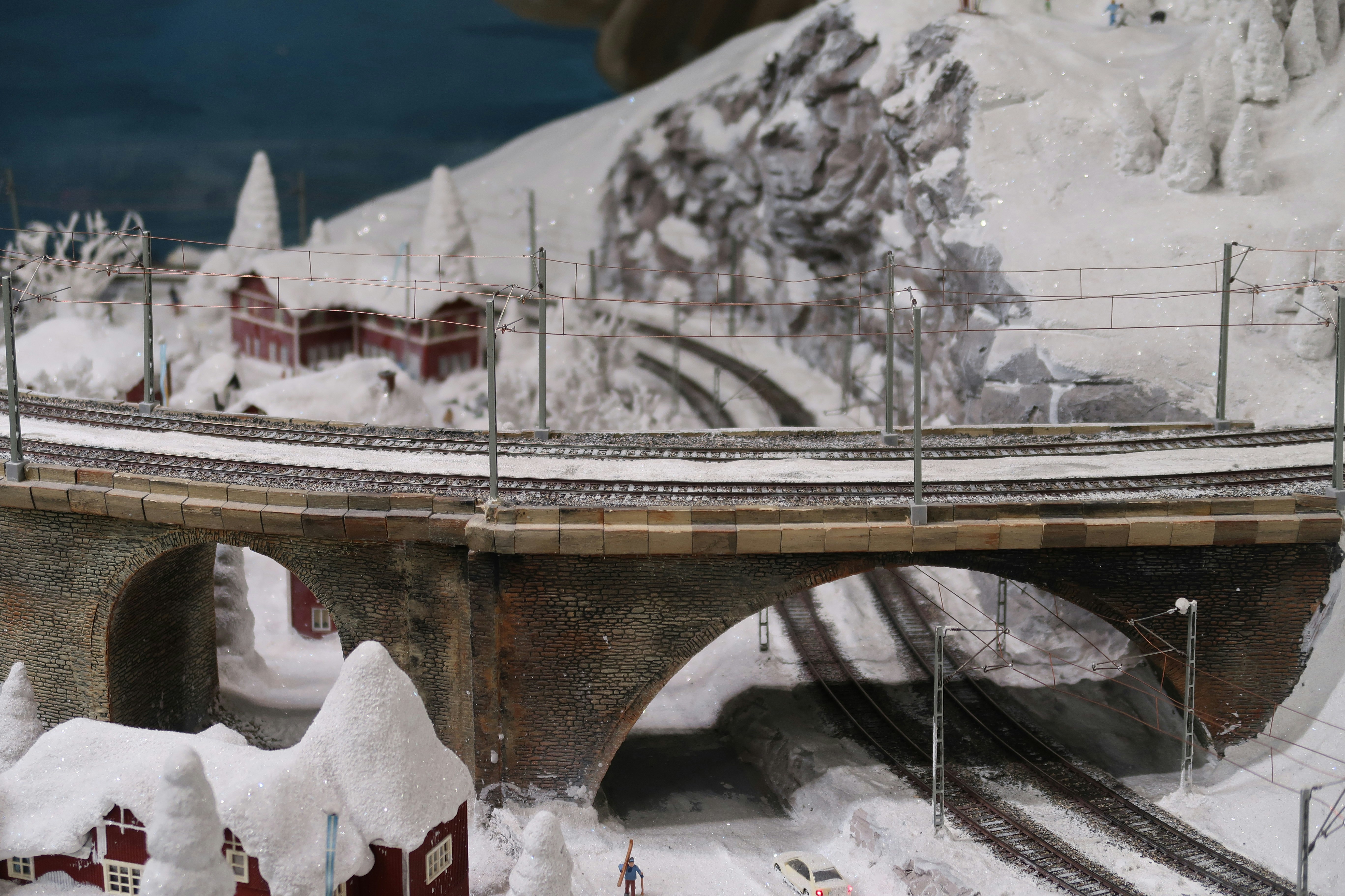 Snow-covered miniature landscape with train tracks and houses