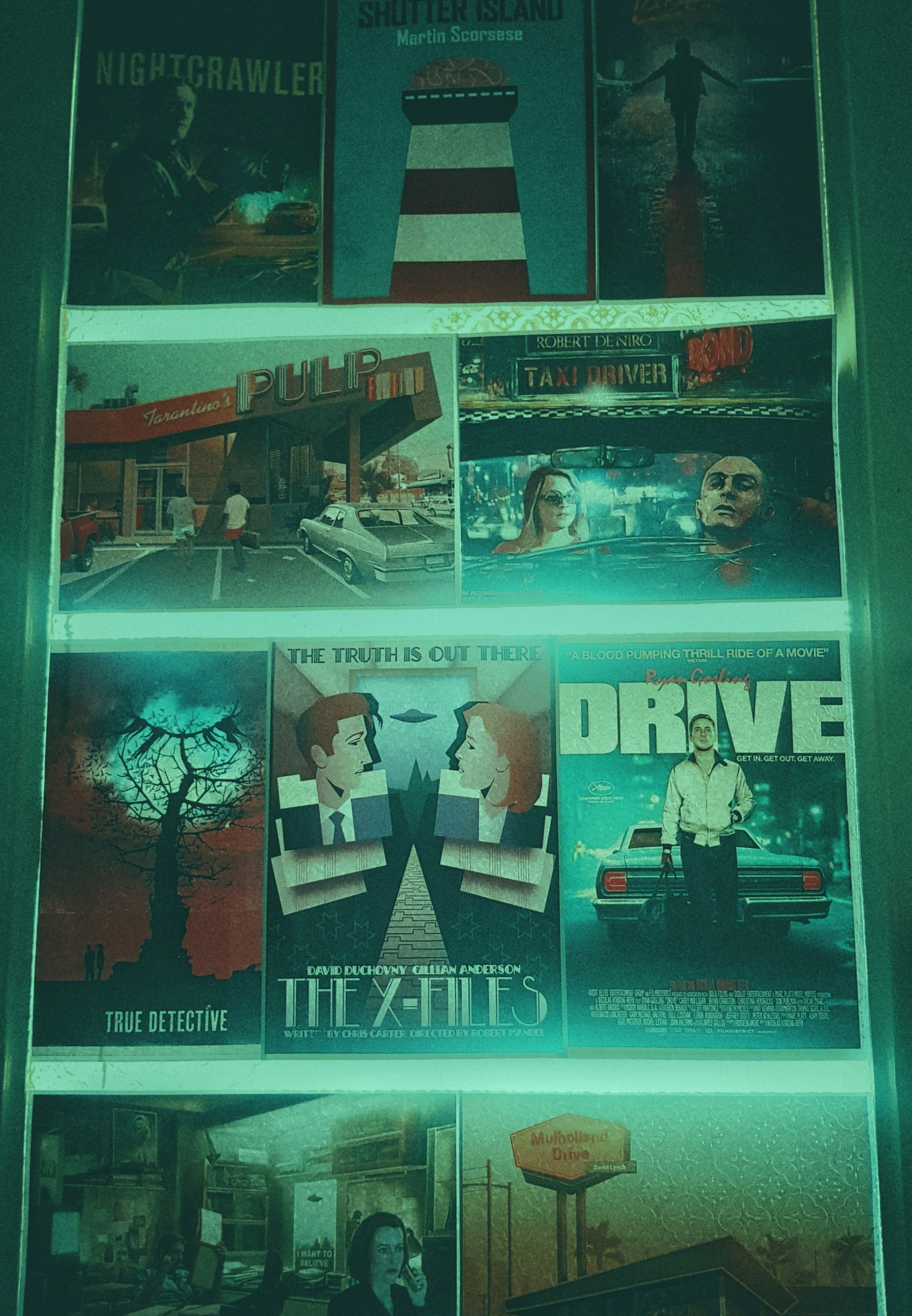 Collection of movie and TV show posters under green light.