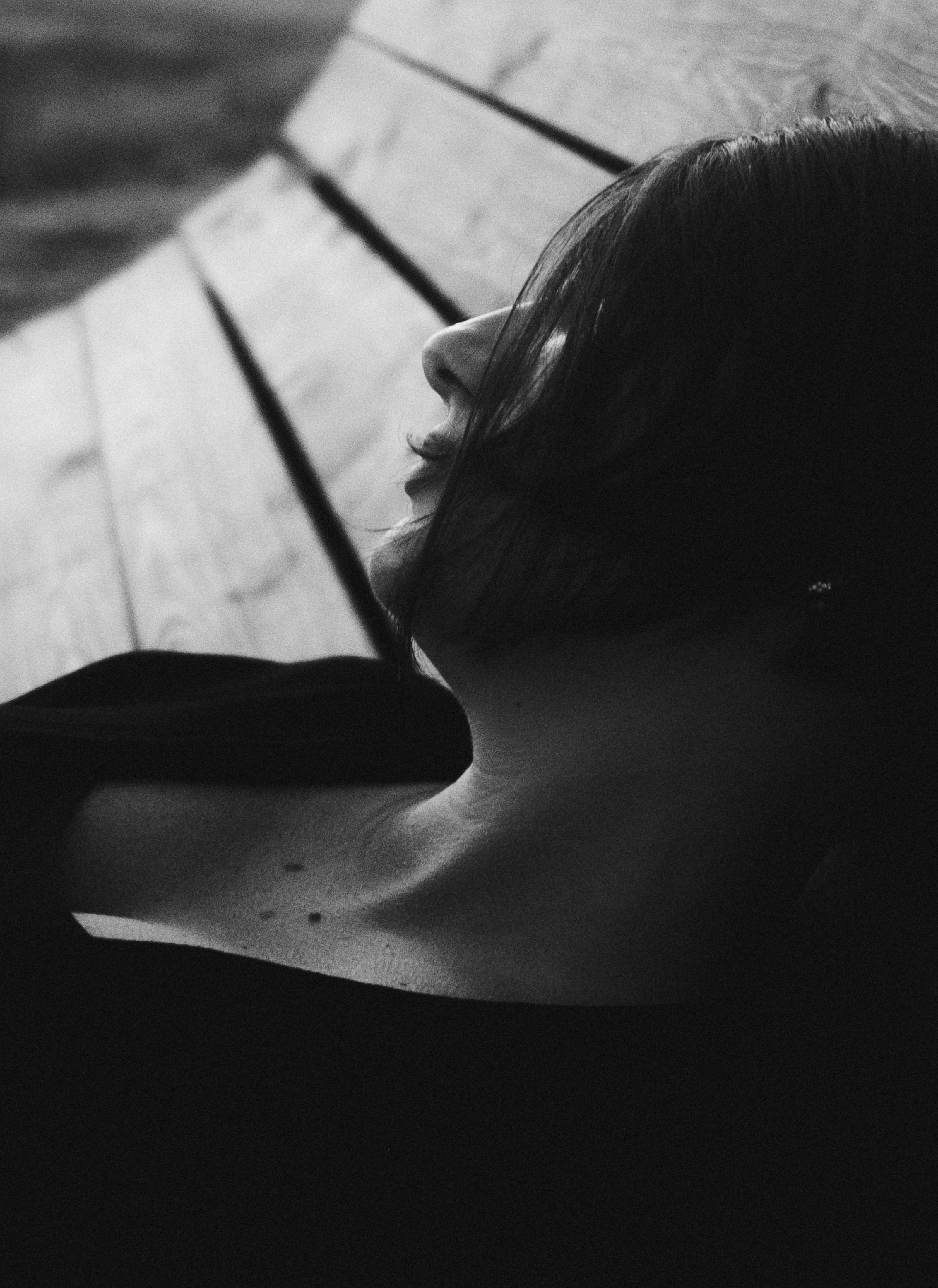 Woman relaxing on a wooden bench in black and white.