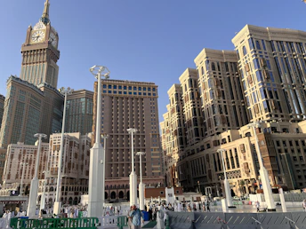 Mecca cityscape with historic clock tower and modern buildings.