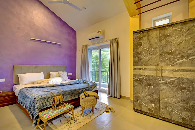 Quarto real elegante com parede de destaque em roxo ameixa e varanda