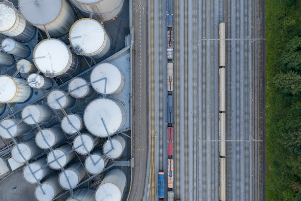 Overhead view of industrial silos and a train on tracks.