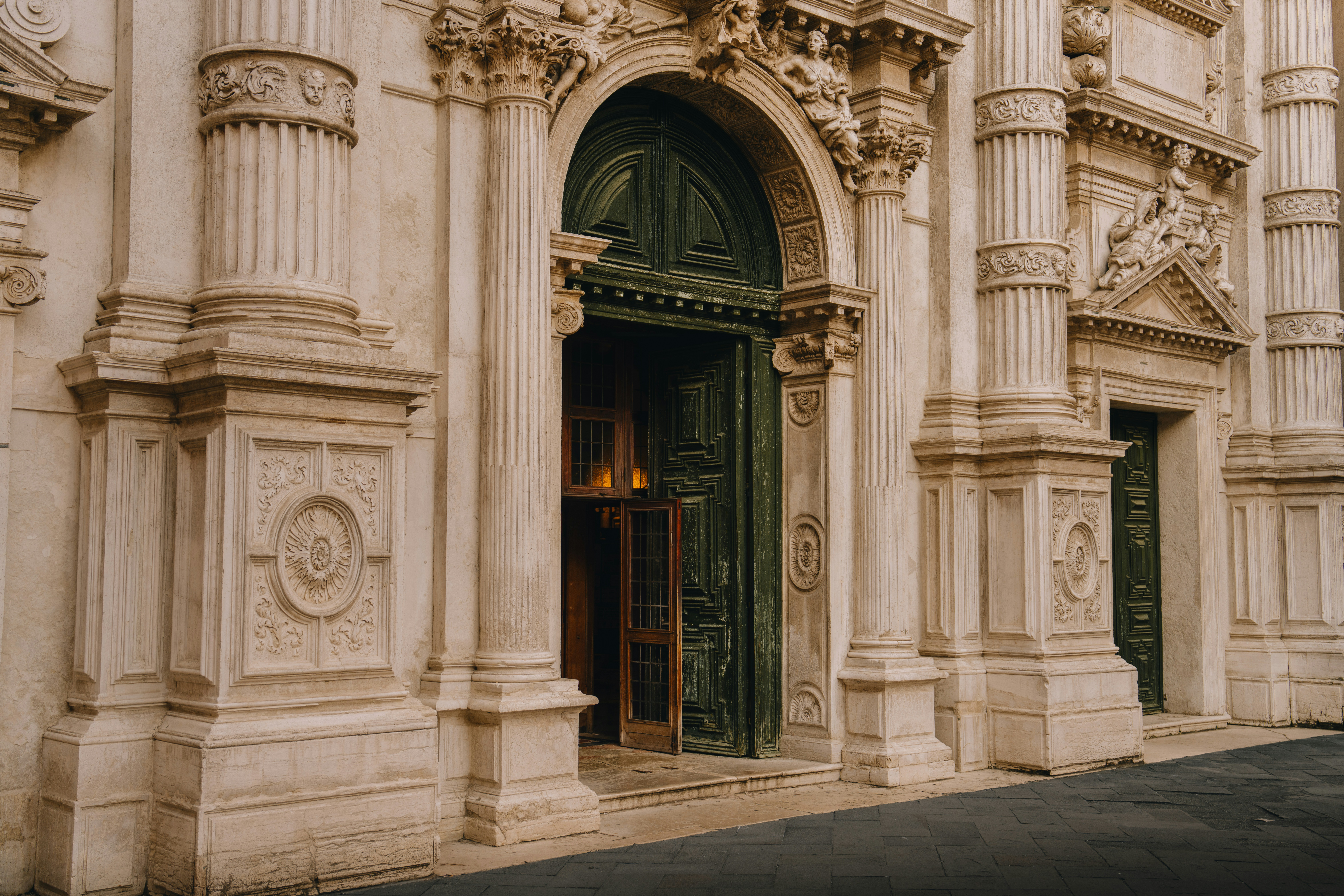 Ornate architectural facade with columns and a dark green door