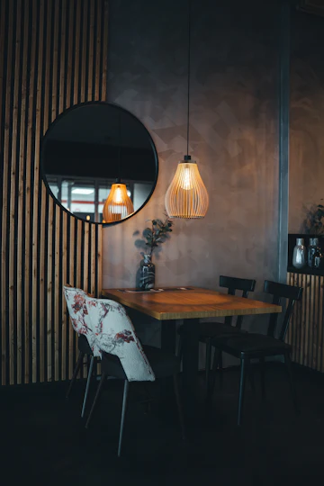 Small dining table with a round mirror and hanging lamp