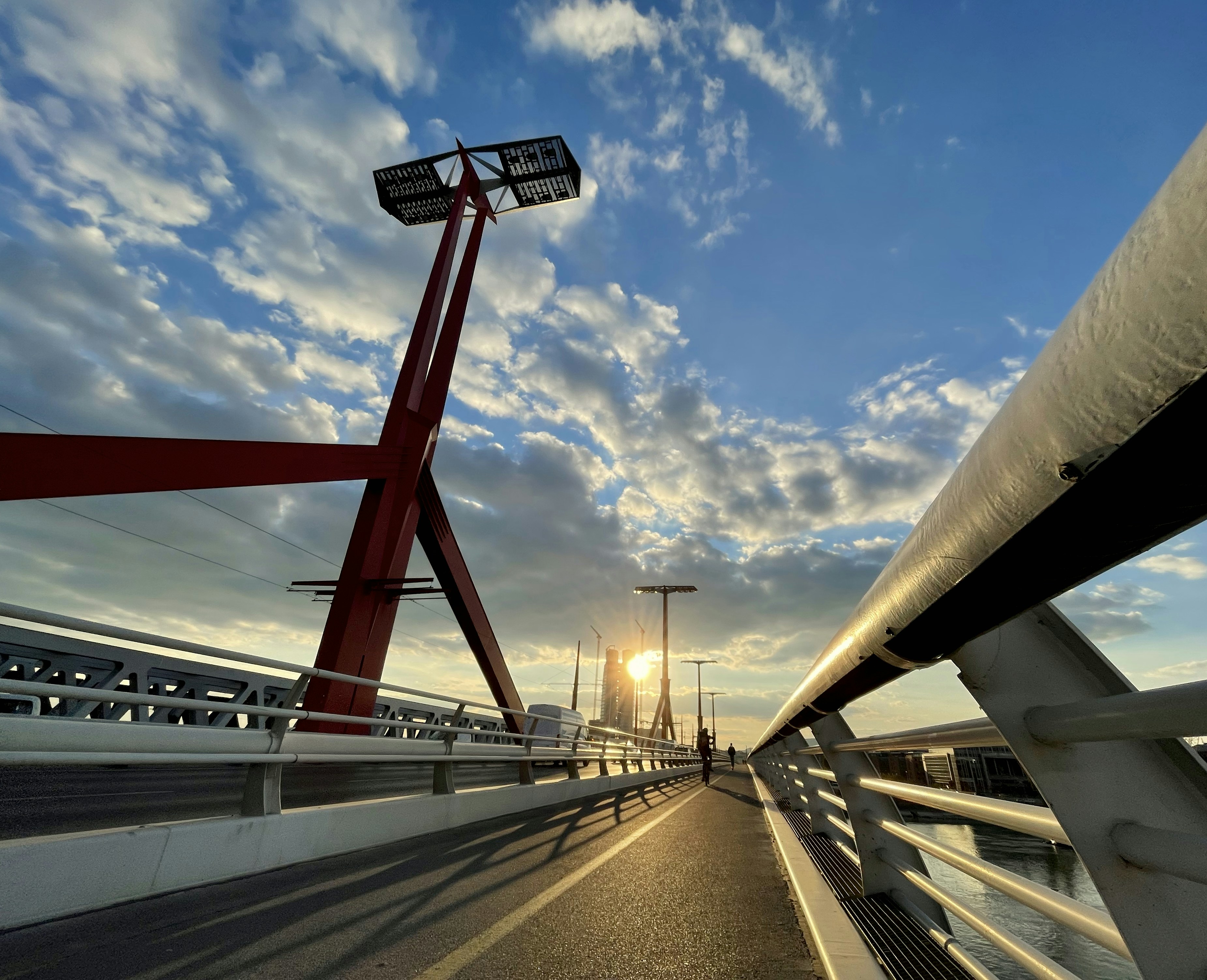 Red bridge structure against a beautiful cloudy sunset sky.