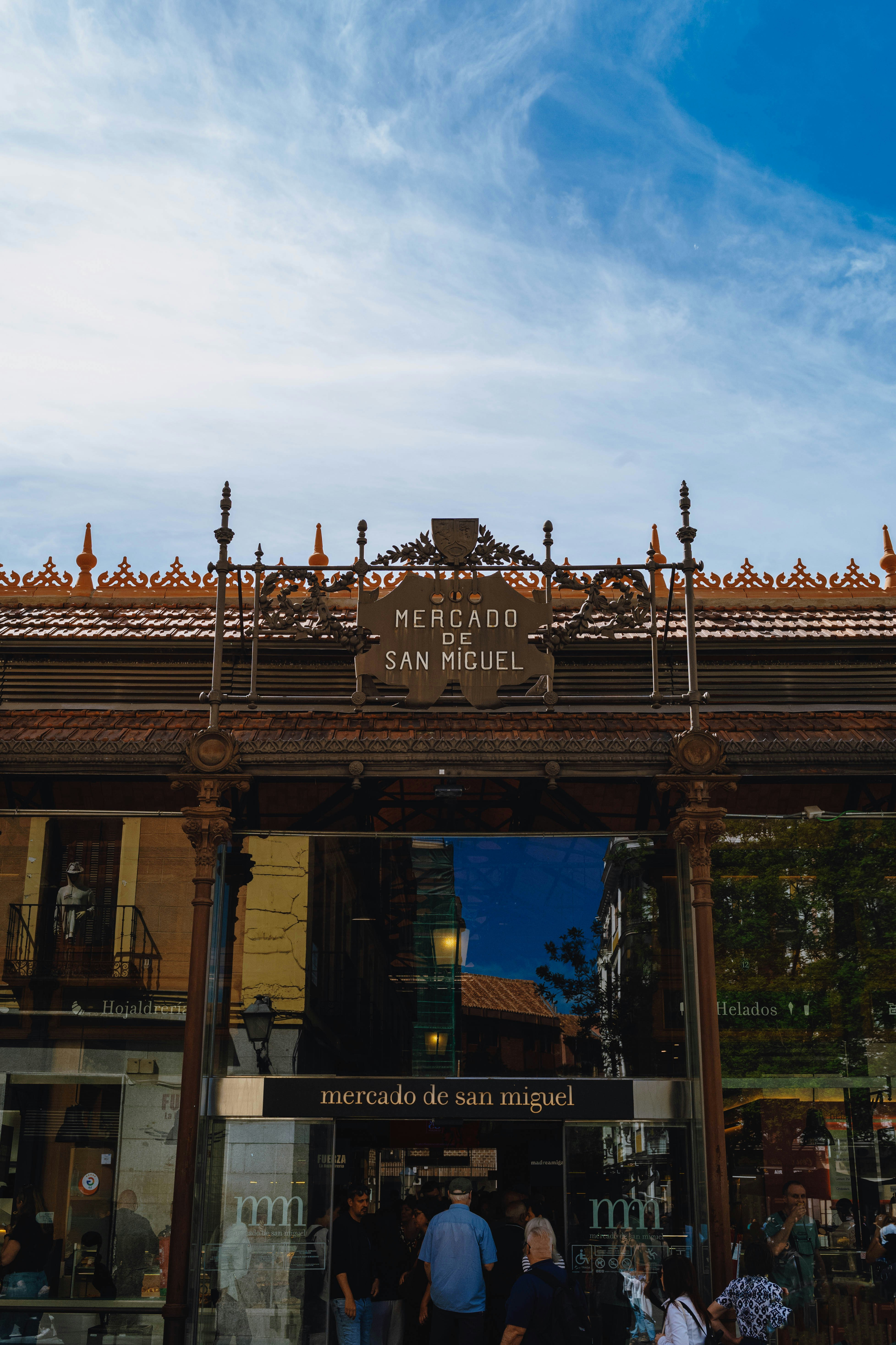 Mercado de san miguel entrance under a bright blue sky.