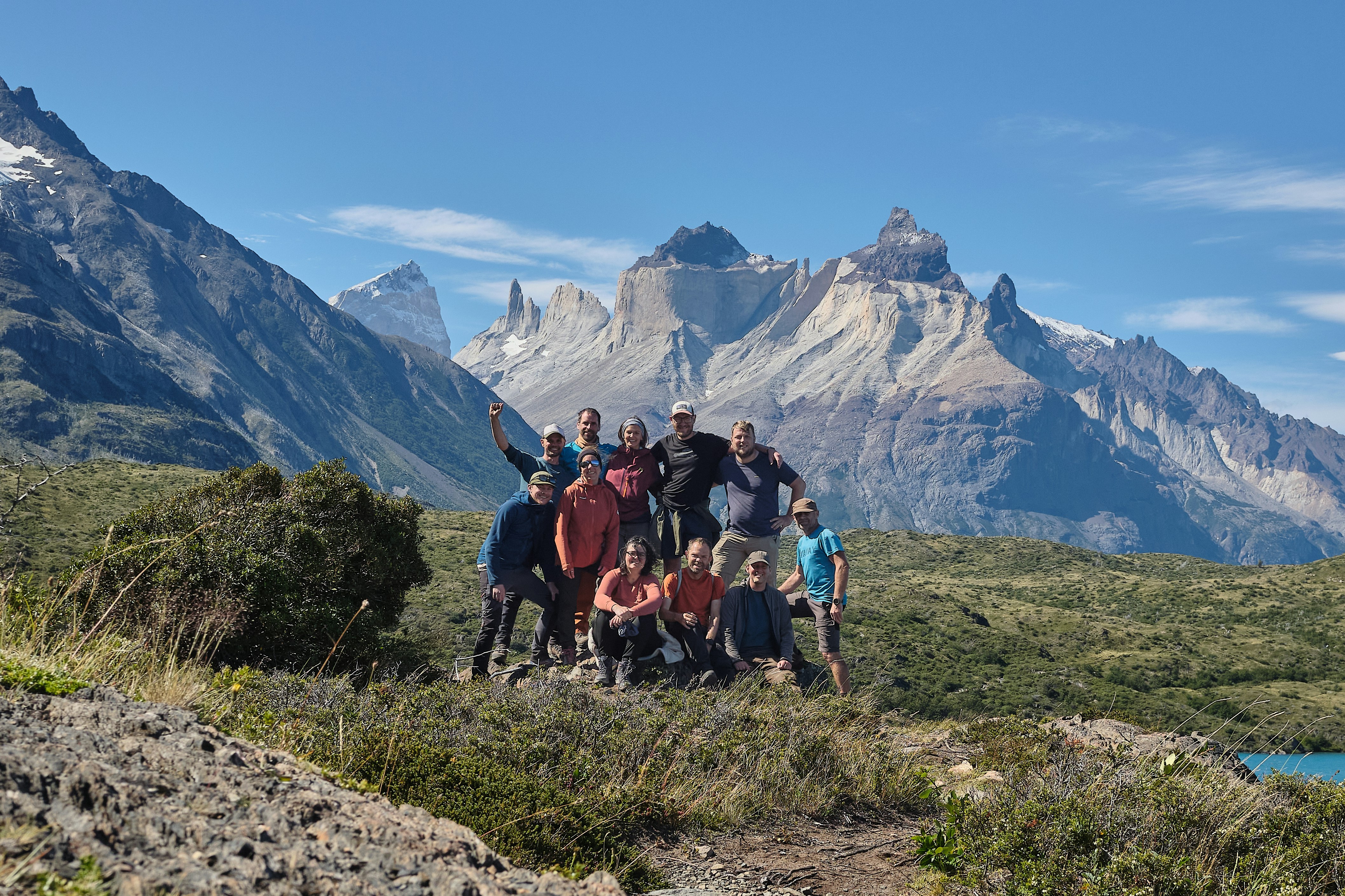 A group of hikers poses in front of majestic mountains.