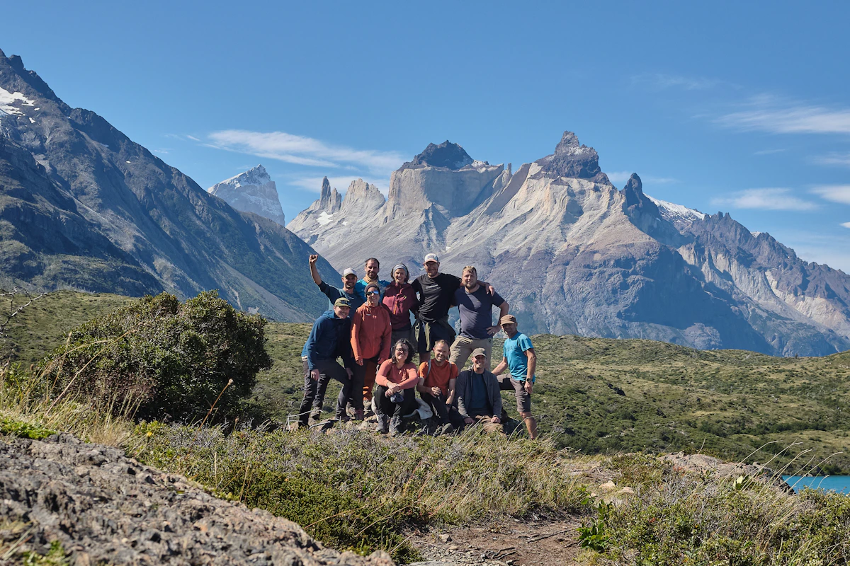 A group of travellers in front of jagged mountain peaks