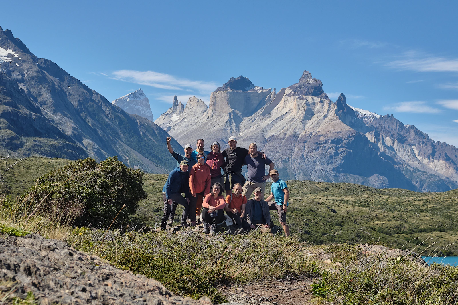 A group of travellers in front of jagged mountain peaks
