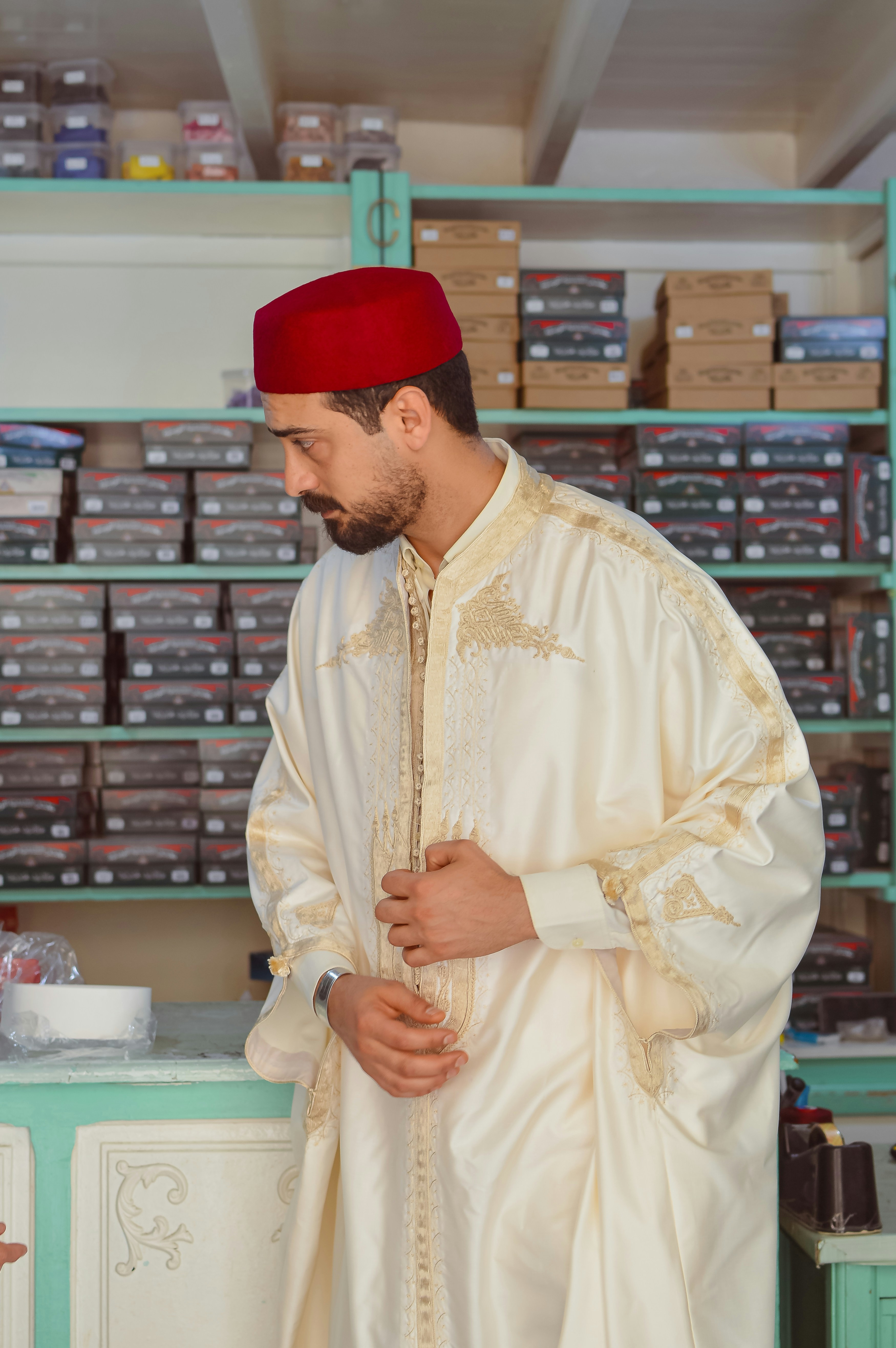 Man in traditional white robe and red fez hat.