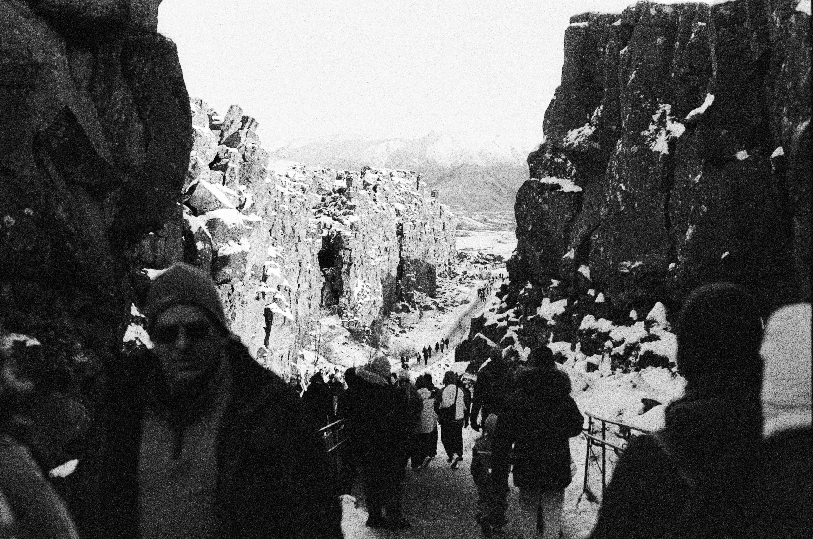People walk through a snowy canyon in a winter landscape.
