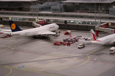 Model airplanes and ground crew vehicles at a miniature airport.