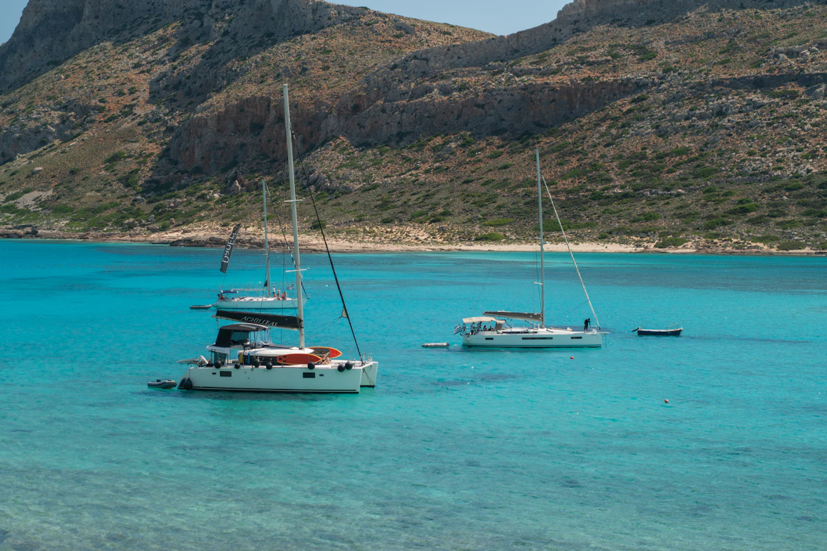 Catamarano e barca a vela ormeggiati in una baia dall'acqua turchese