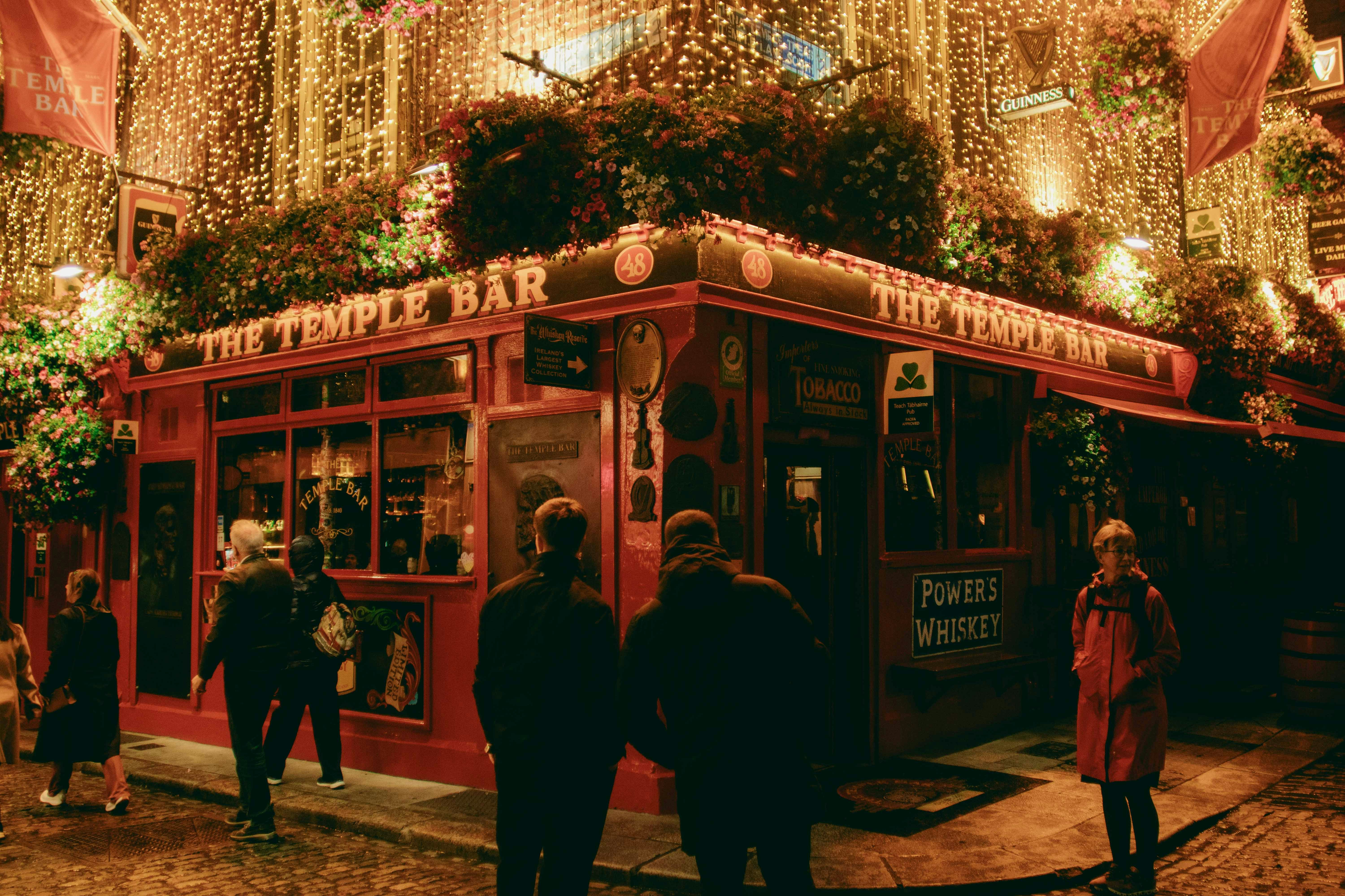 Cozy red pub decorated with sparkling lights at night.