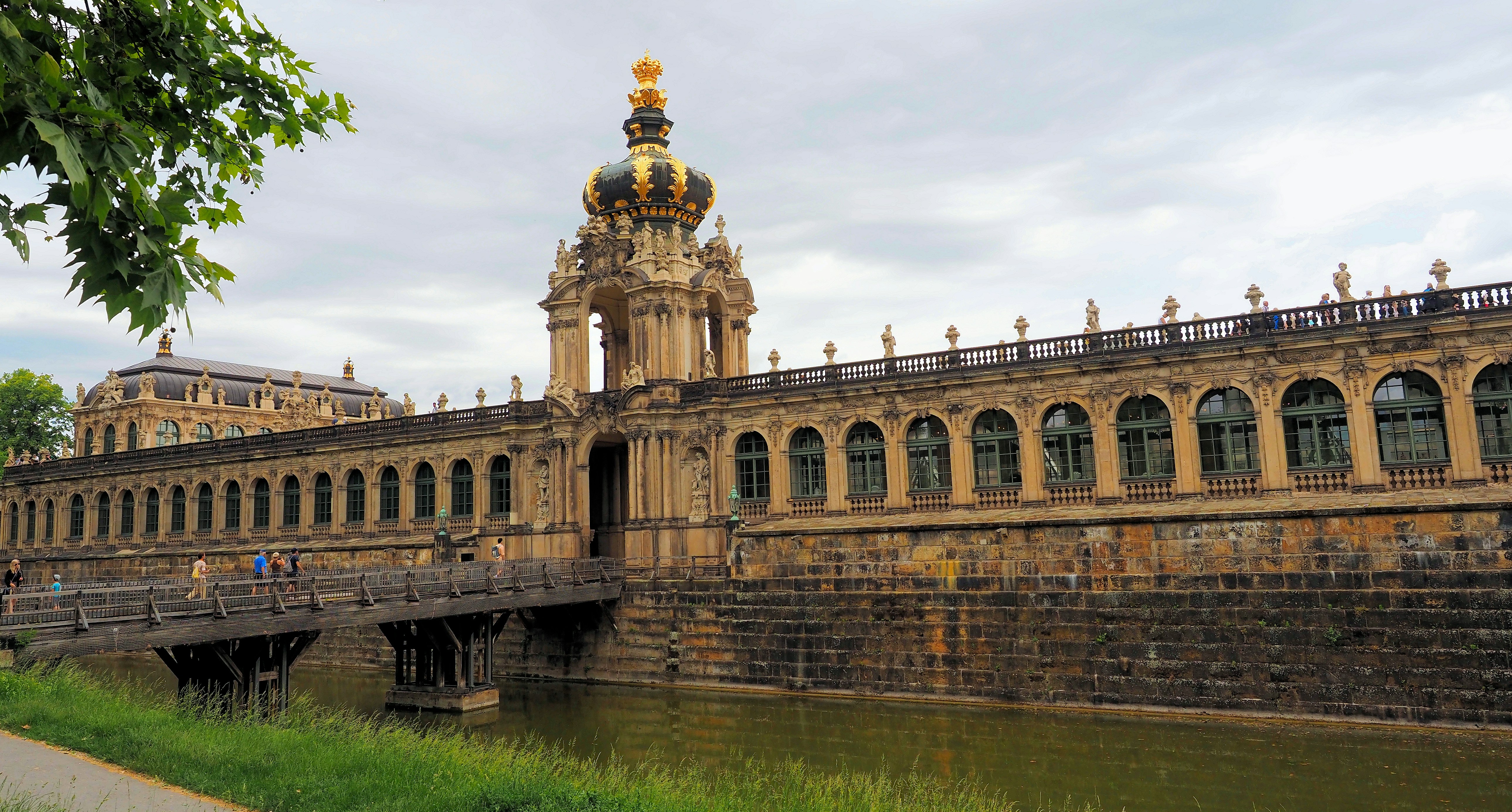 Historic european palace with golden crown and bridge over moat