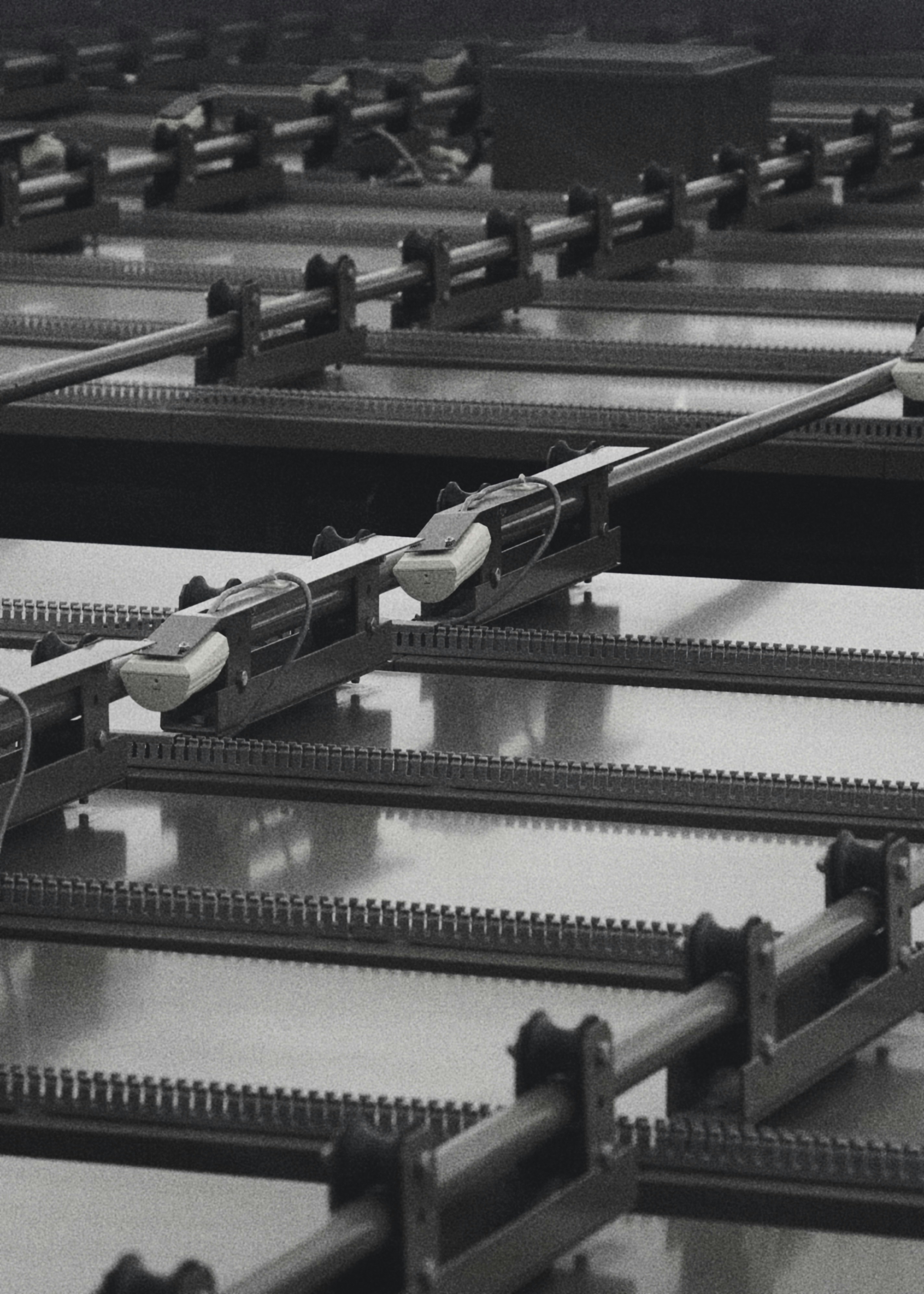 Rows of industrial machinery with rails and moving parts.