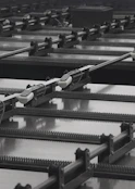 Rows of industrial machinery with rails and moving parts.