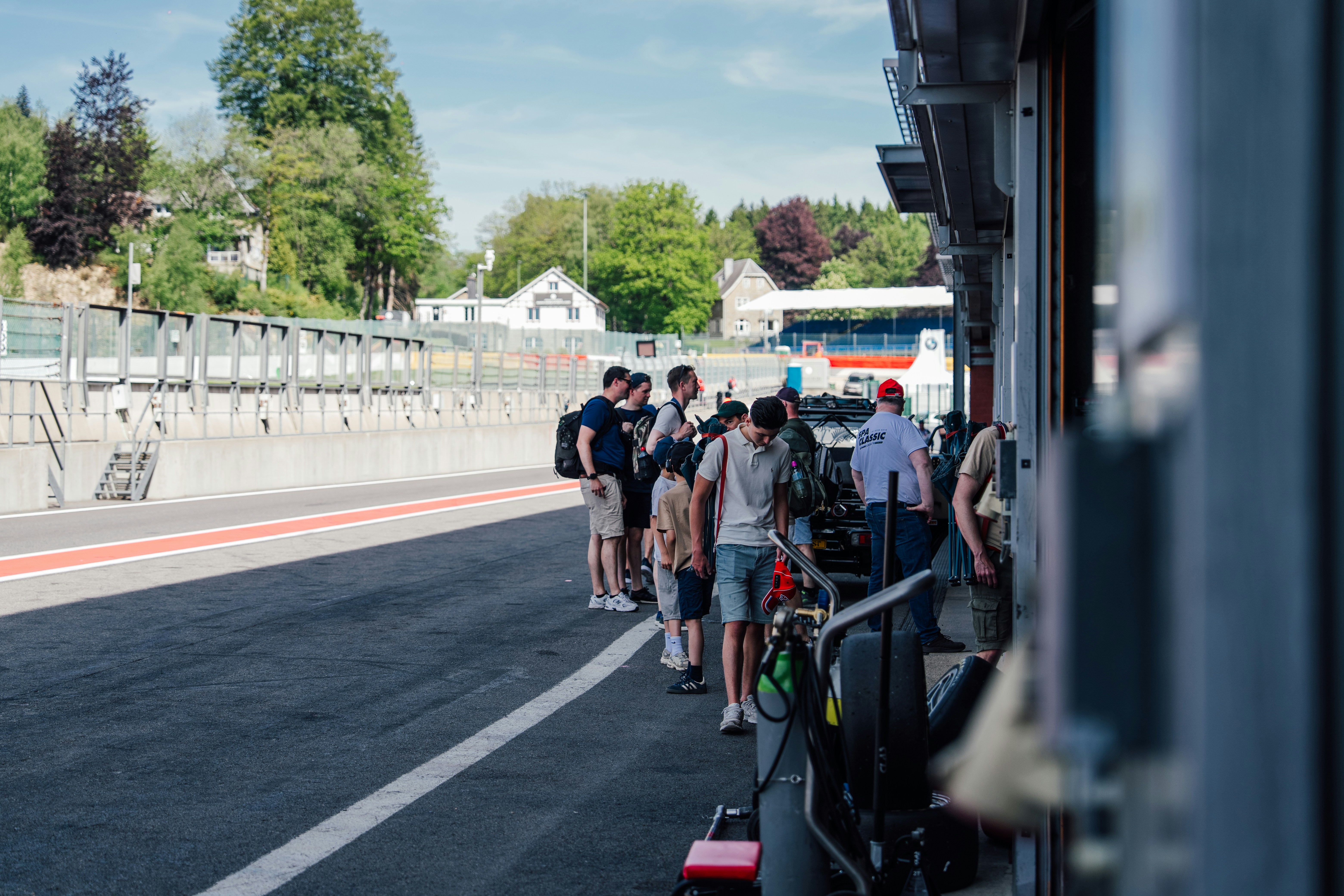 Group of people standing beside a race track.