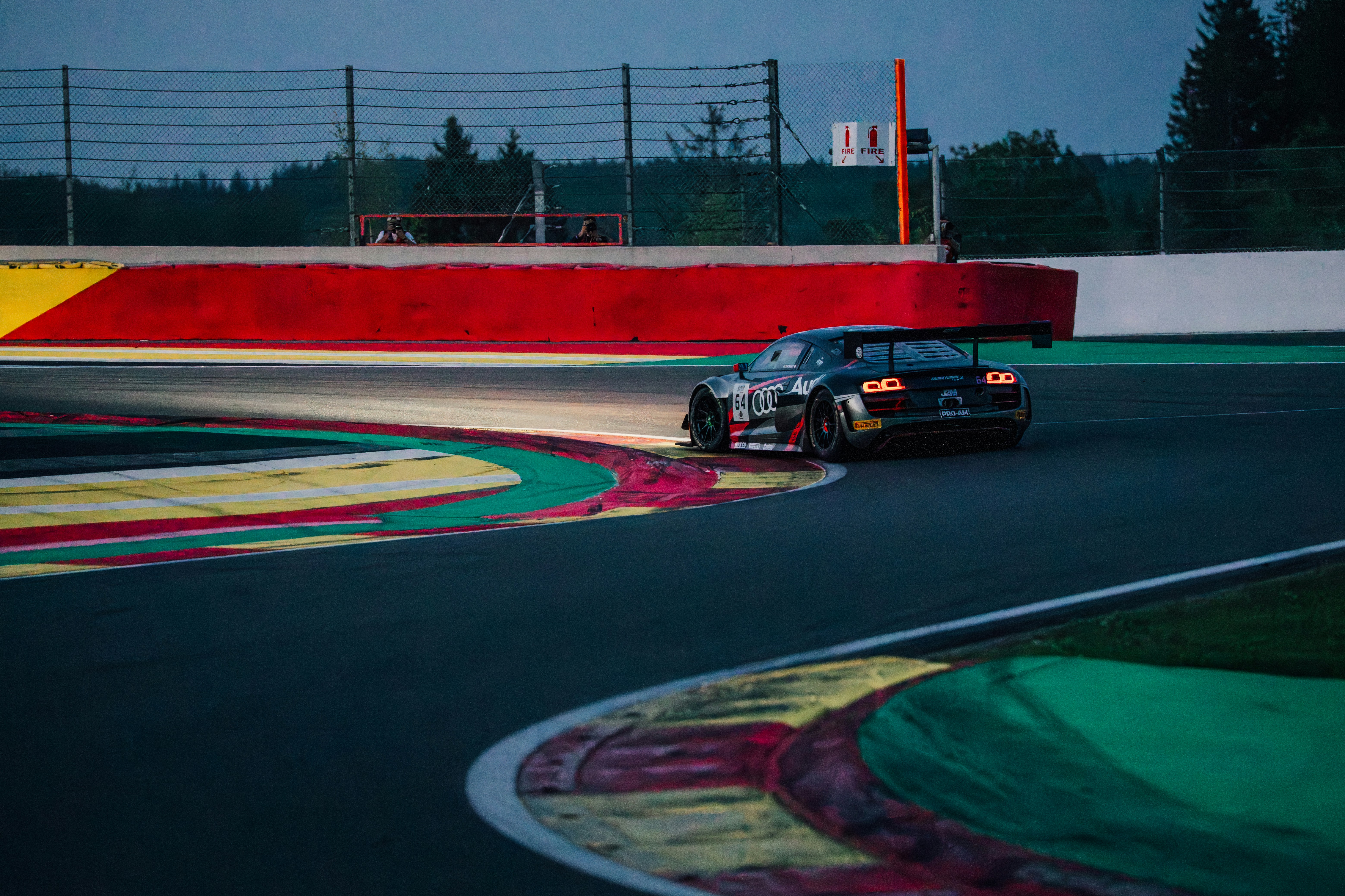Race car driving on a track at twilight.
