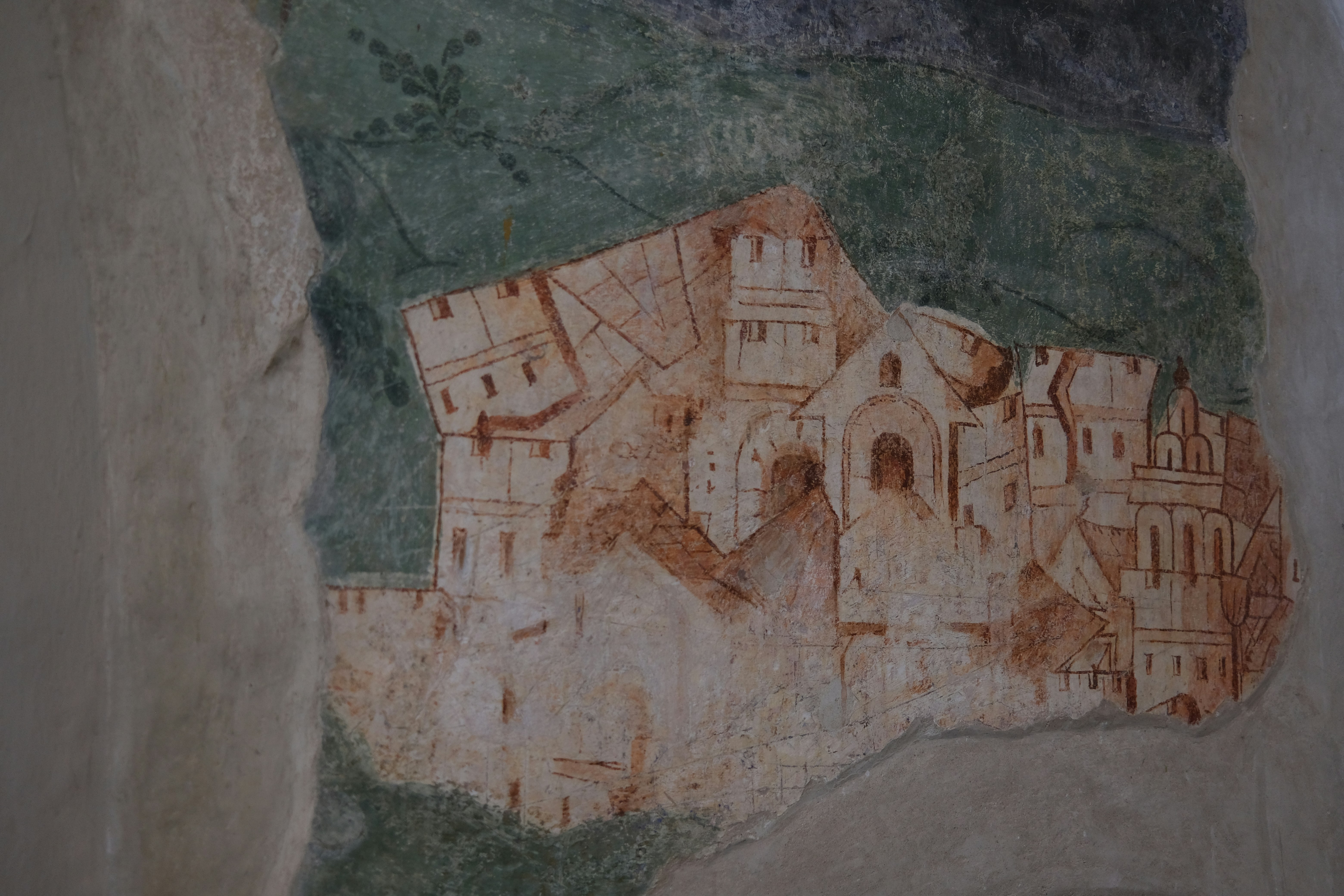 Ancient fresco depicting a fortified village on a green hillside.